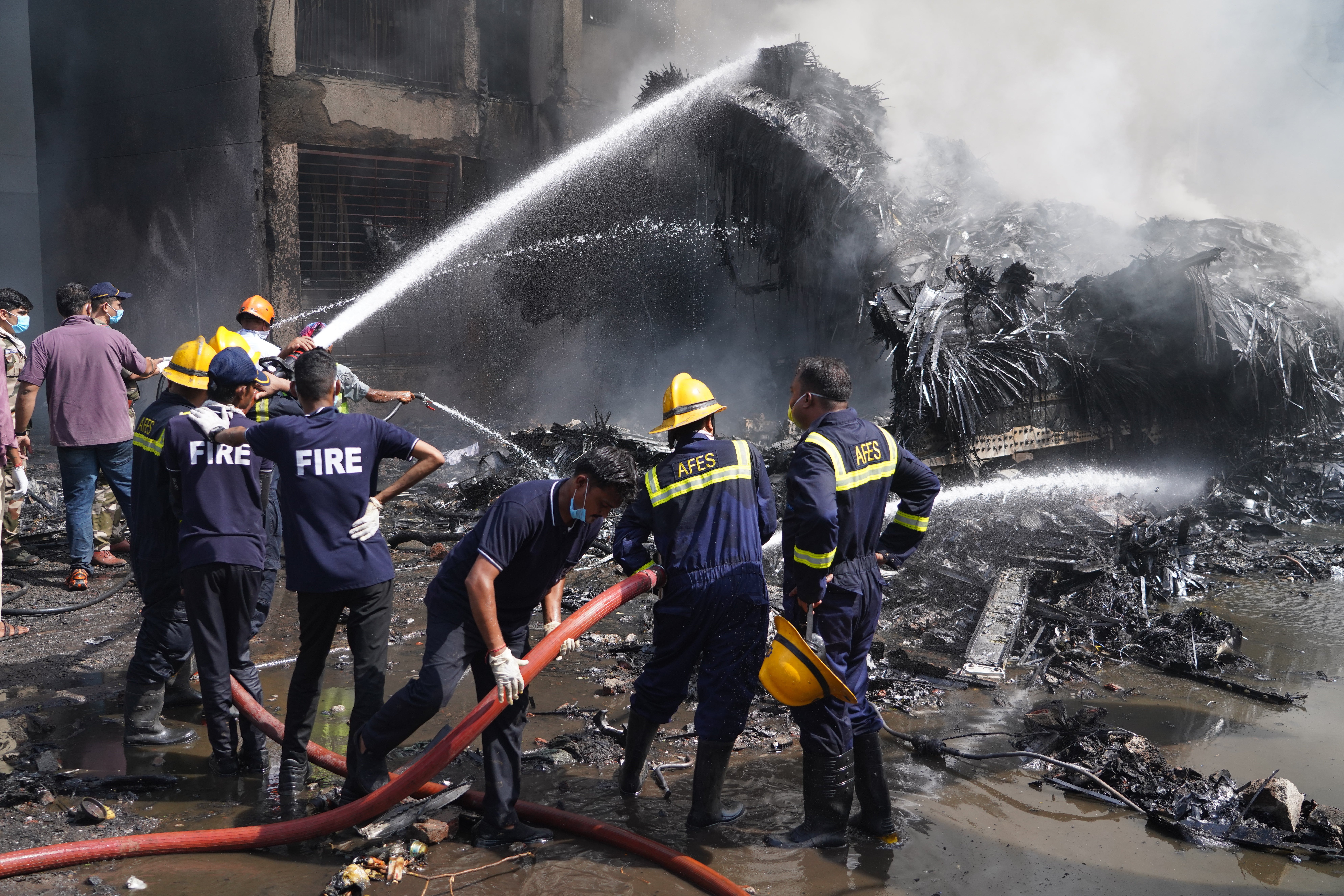 Firefighters work at the site of the plane crash