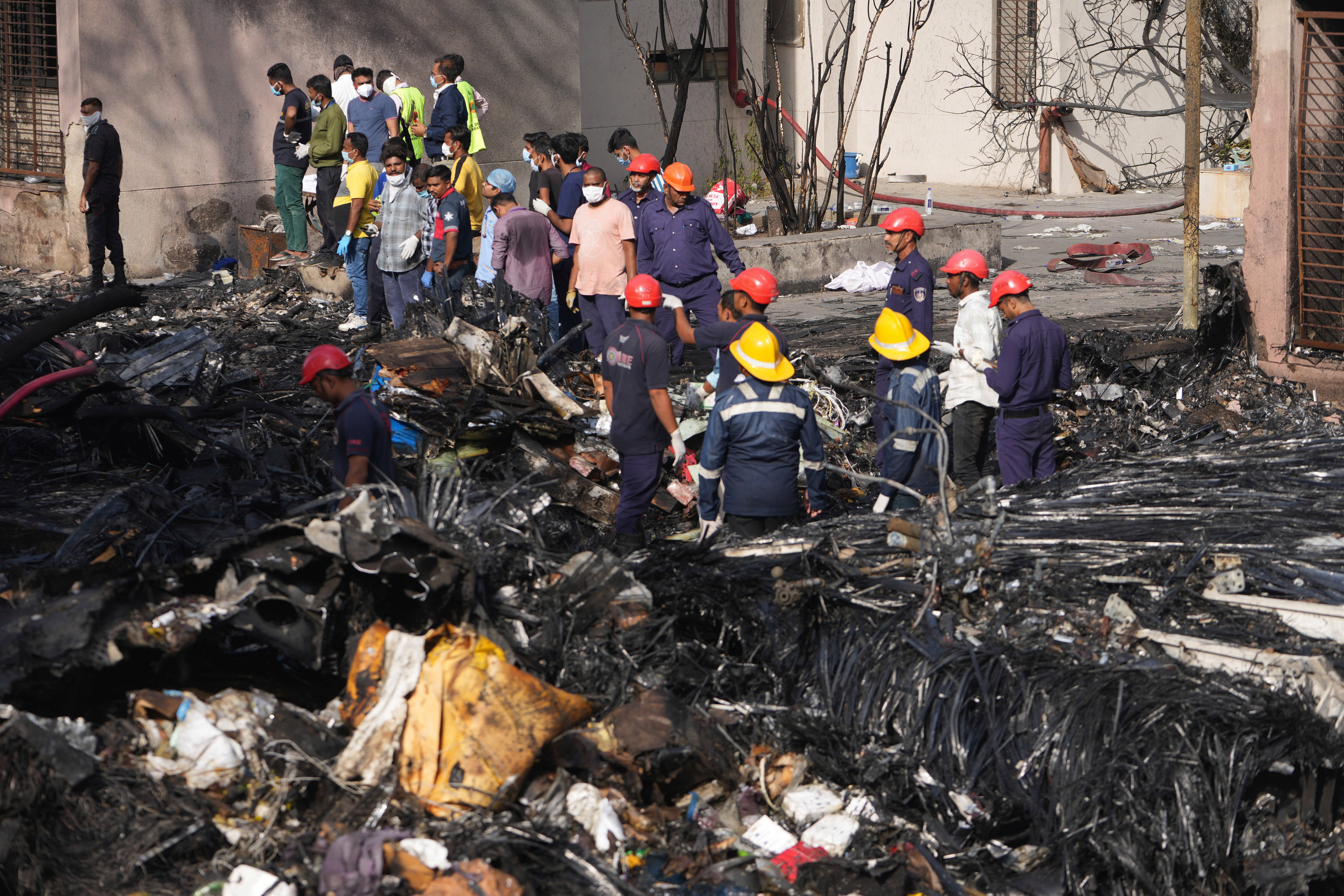 Rescue teams work at the scene of the crash in Ahmedabad