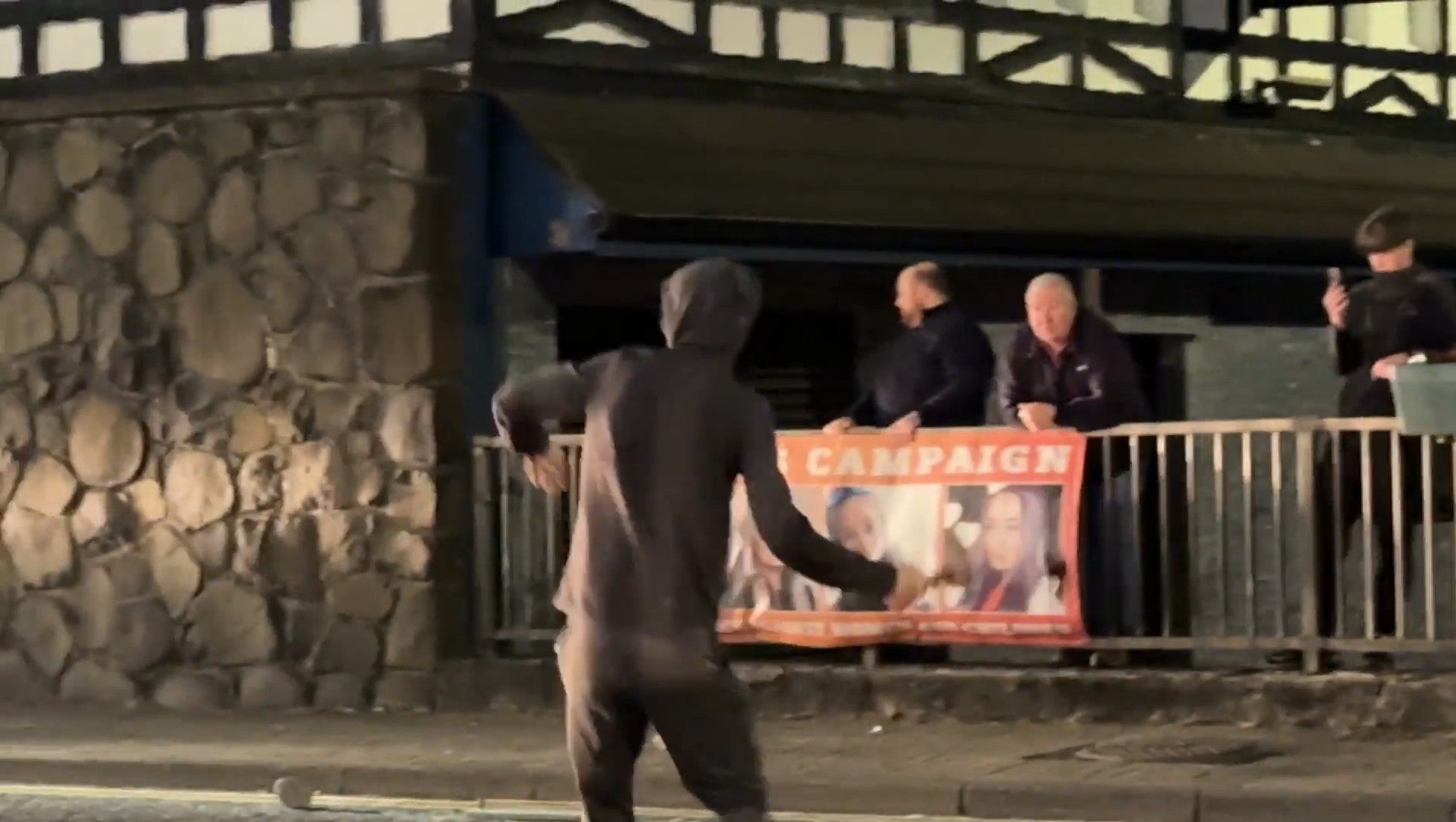 A person throws a hatchet at police during the disorder