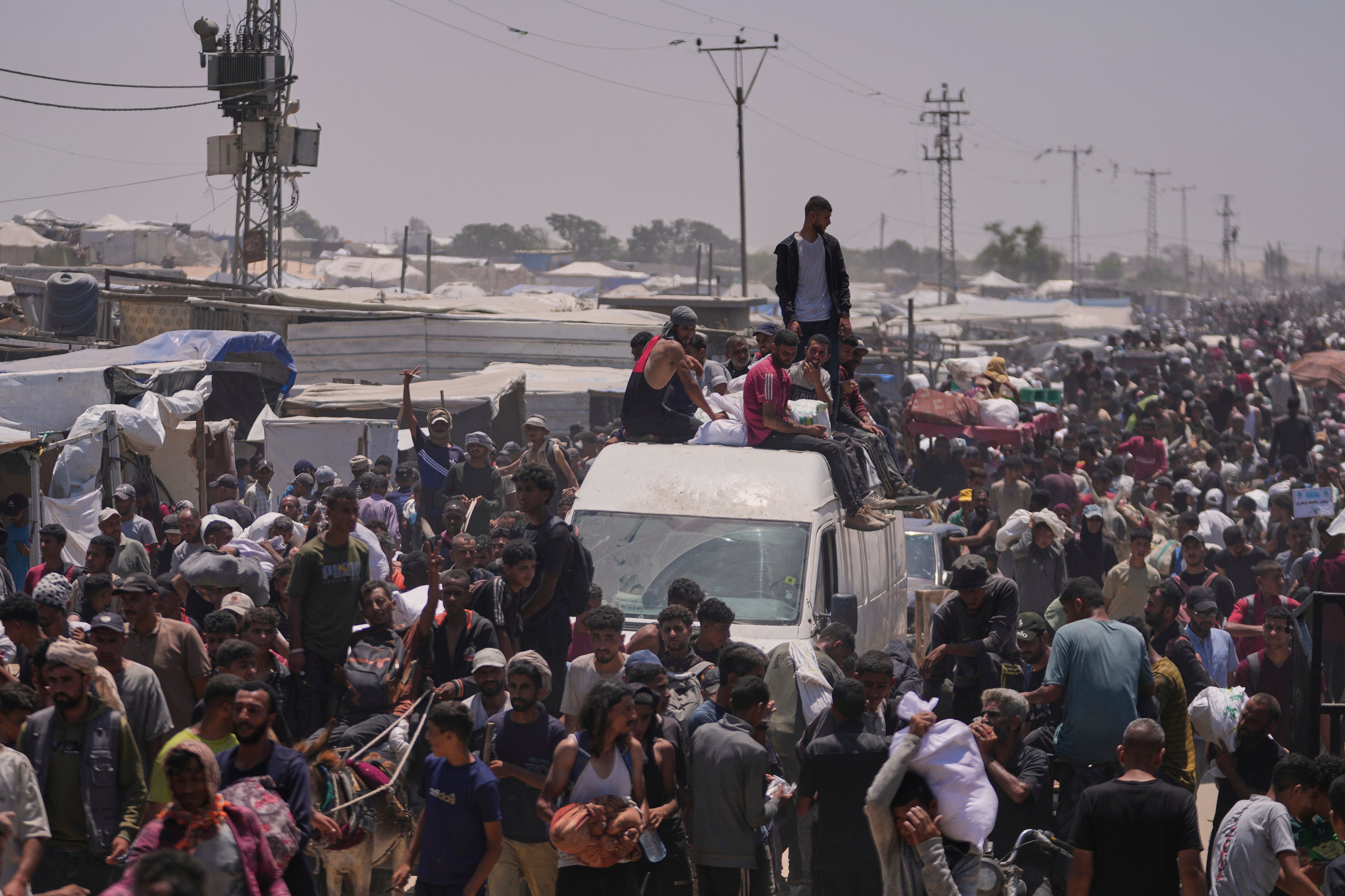 Palestinians carry bags containing food and humanitarian aid packages in Rafah