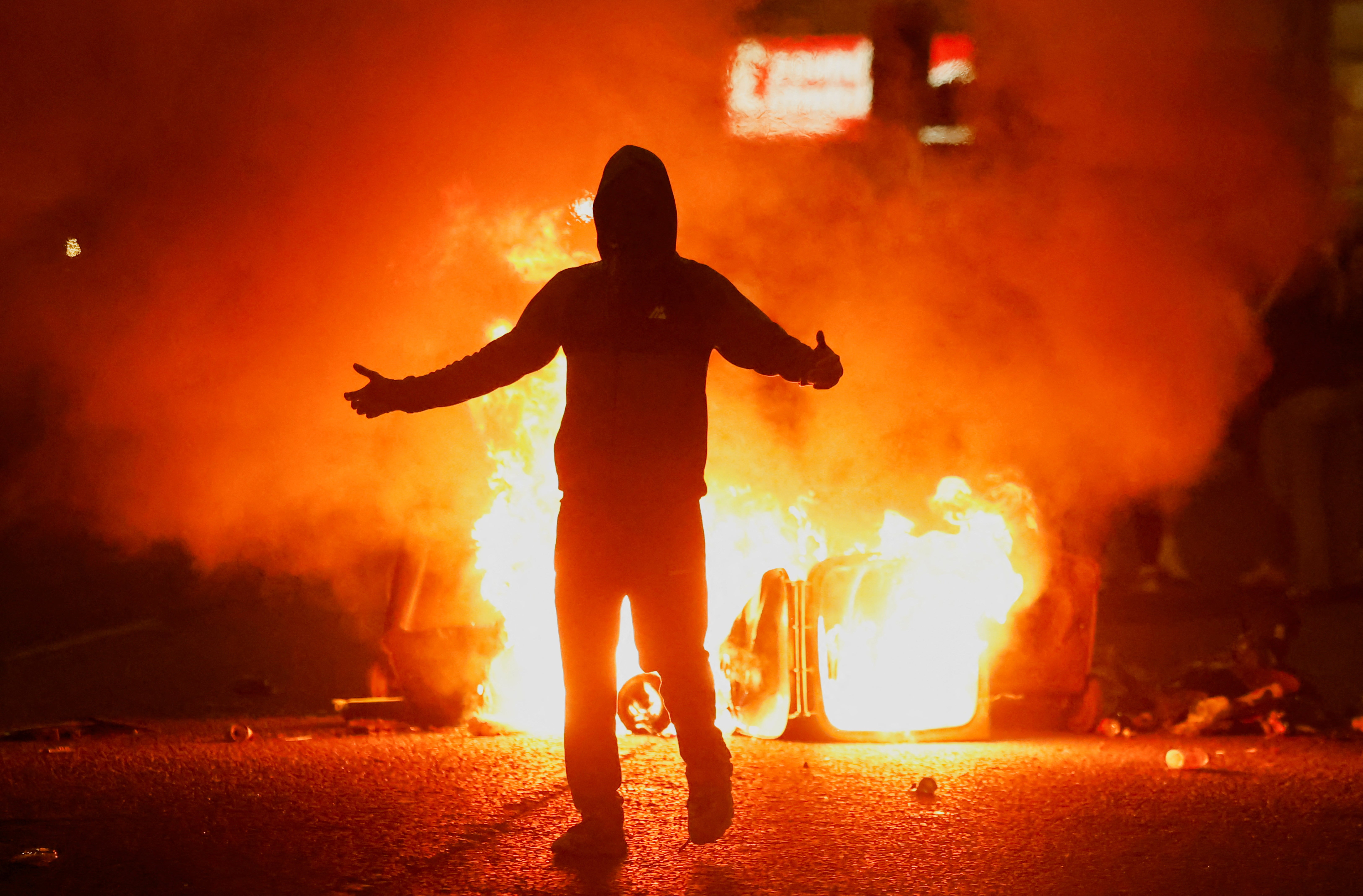 A protester stands close to a fire burning in Ballymena, where there have been three consecutive nights of disorder