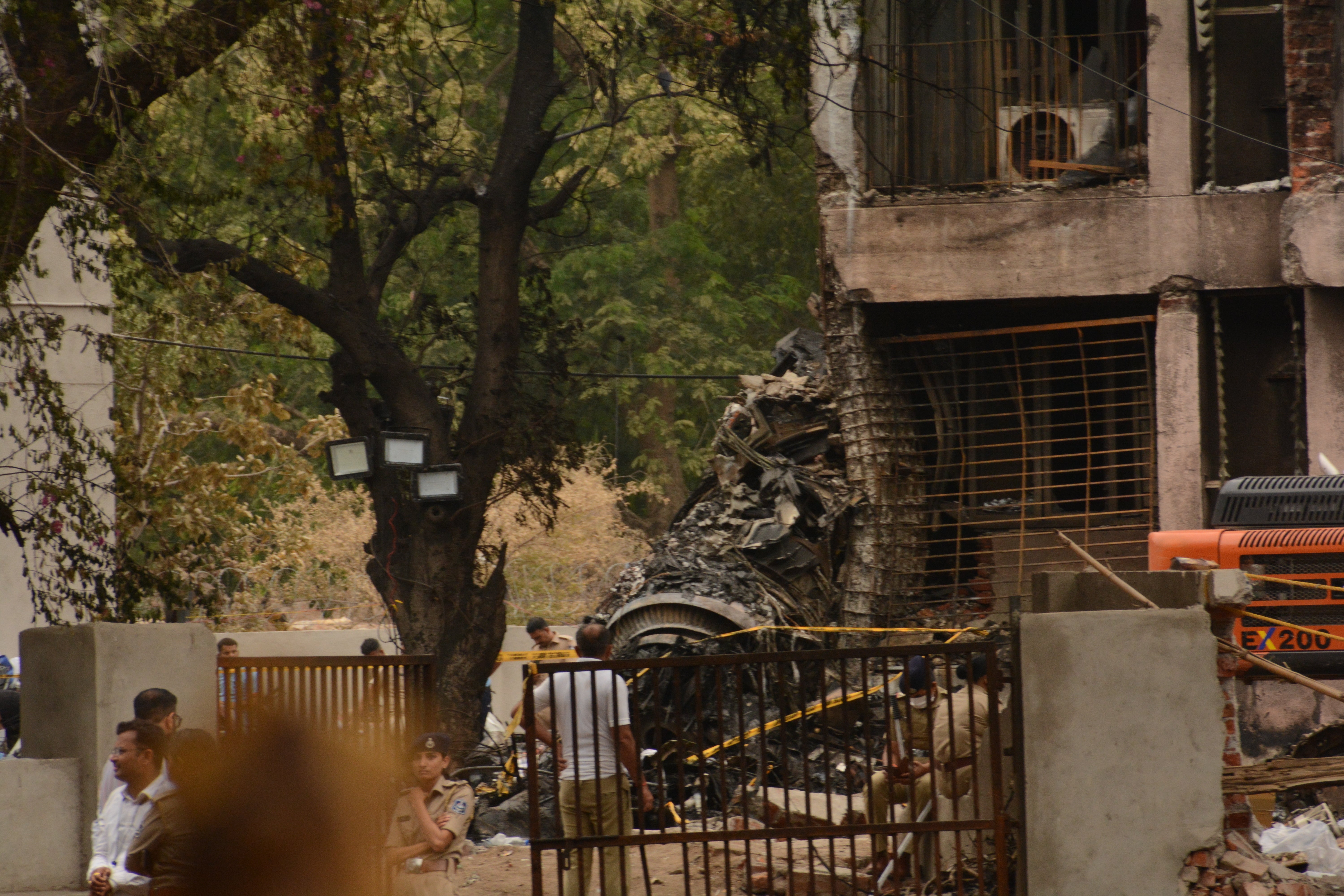 Officials work to clean wreckage after the plane came down in a residential area