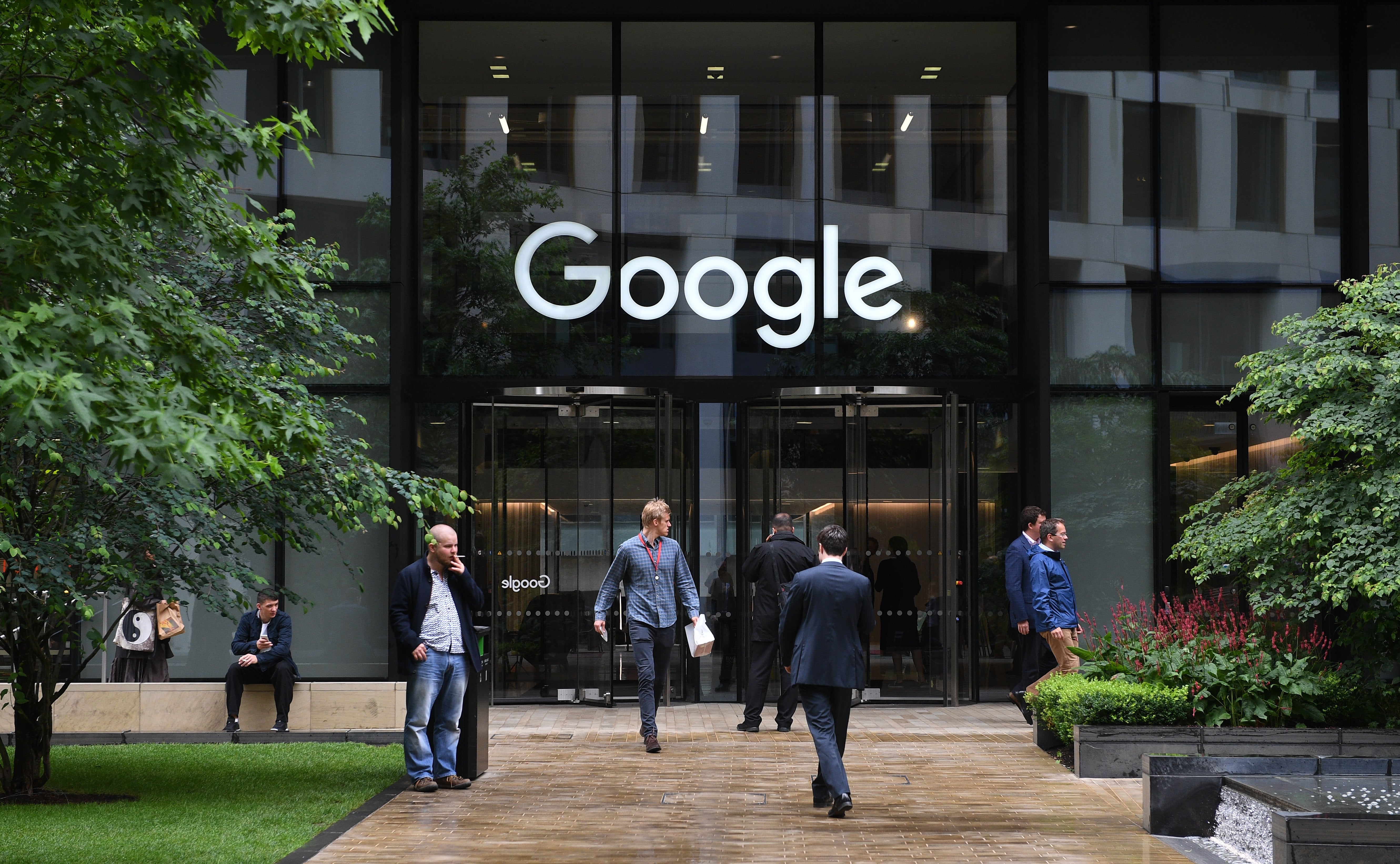Pedestrians walk past by the Google office in St Pancras in London, Britain on June 27, 2017