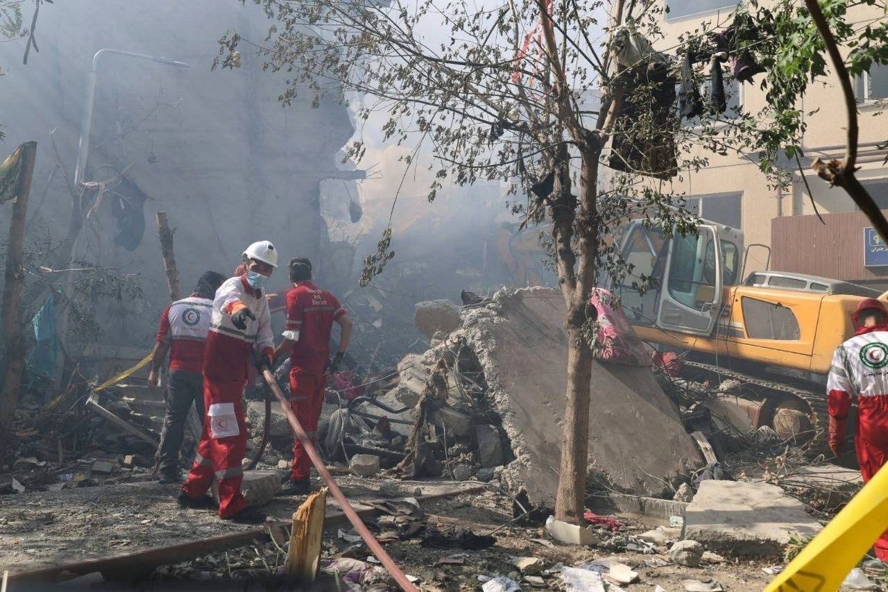Rescuers work at the scene of an explosion after an Israeli strike in Tehran on Friday