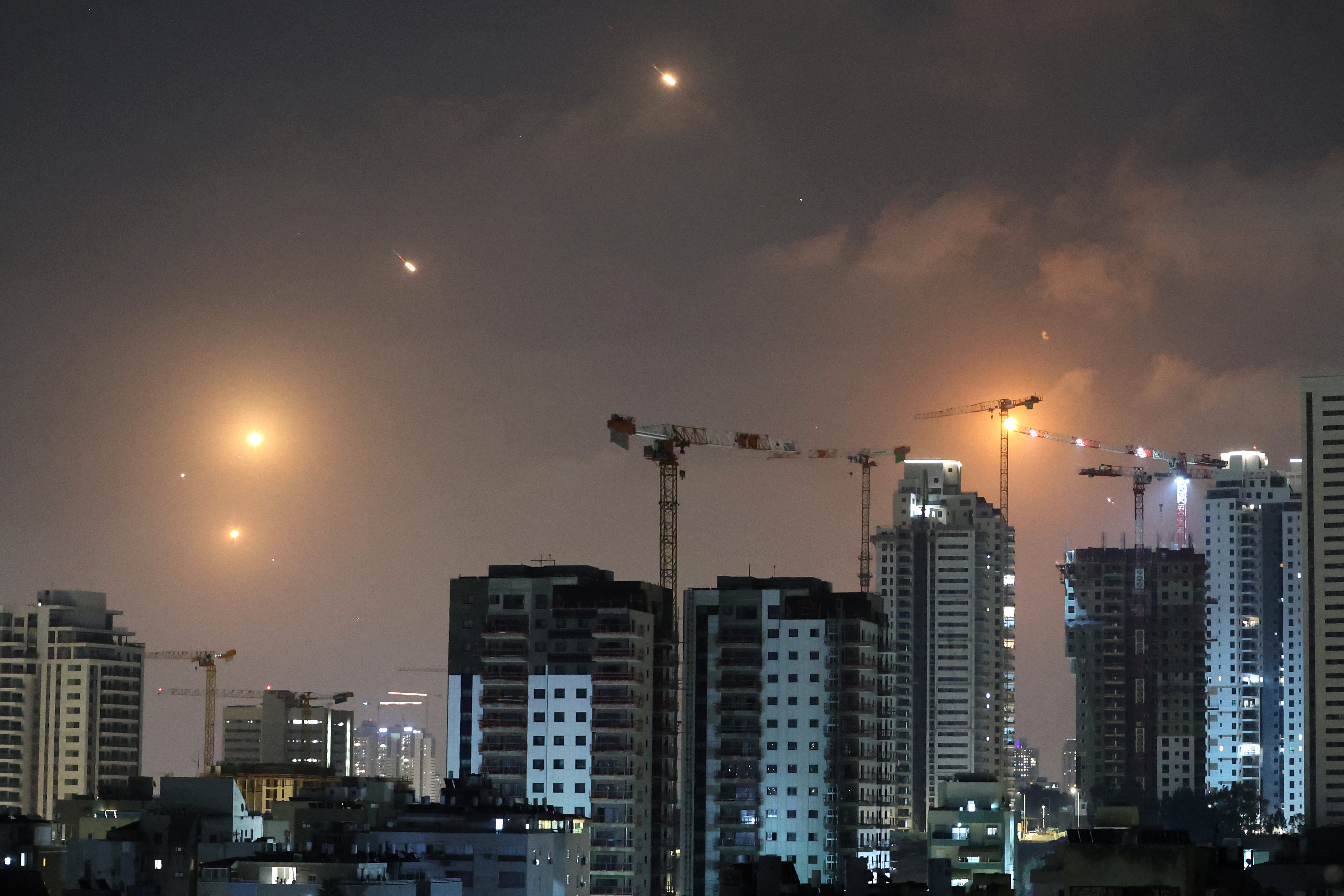 This picture shows rocket trails in the sky above Netanya on June 13, 2025. Air raid sirens sounded in Jerusalem and loud blasts were heard on June 13, AFP journalists reported, as the Israeli military said it had detected a missile launched from Iran