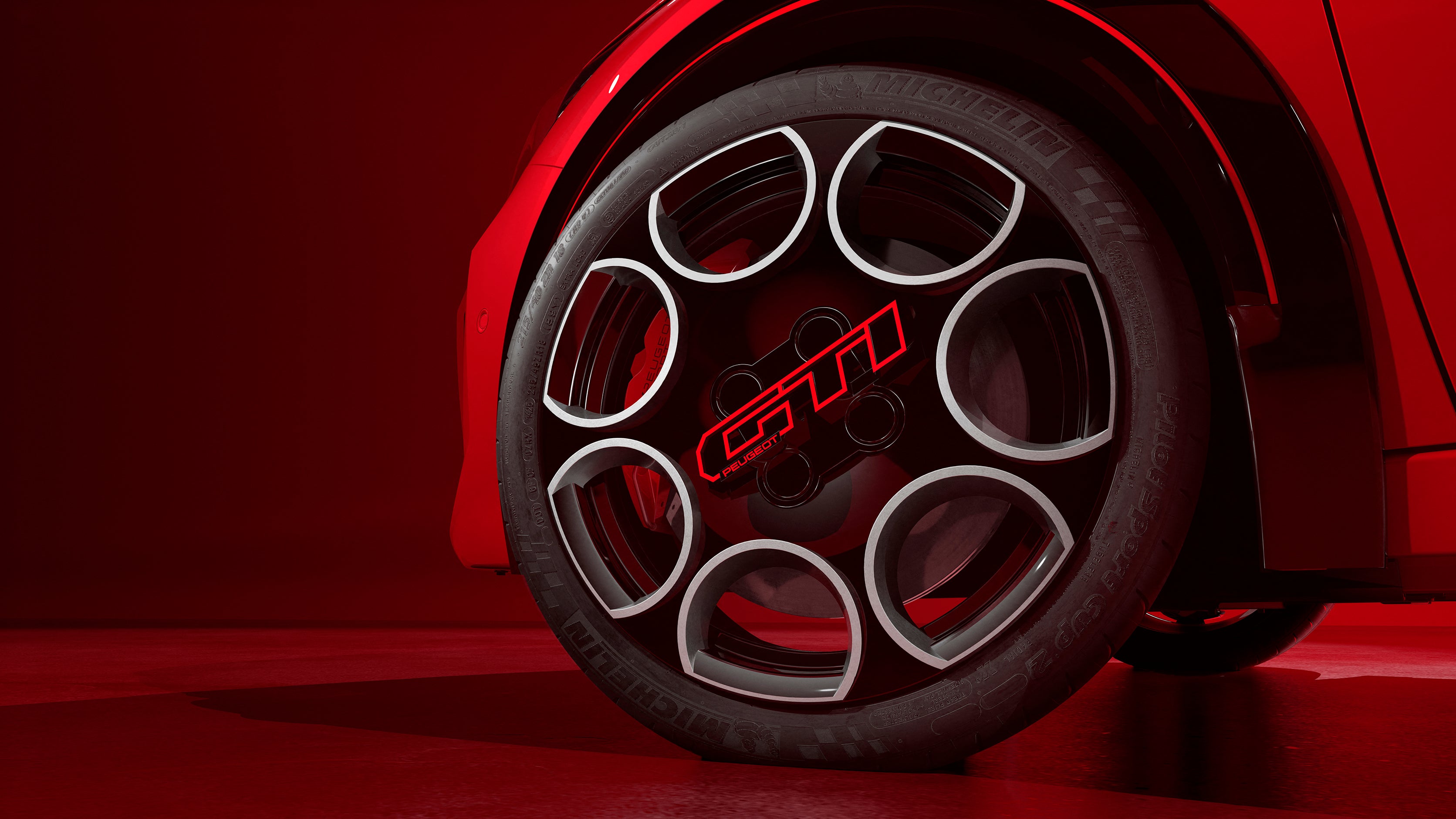 The Peugeot E-208 GTi's wheels feature a bold red GTi logo in the centre