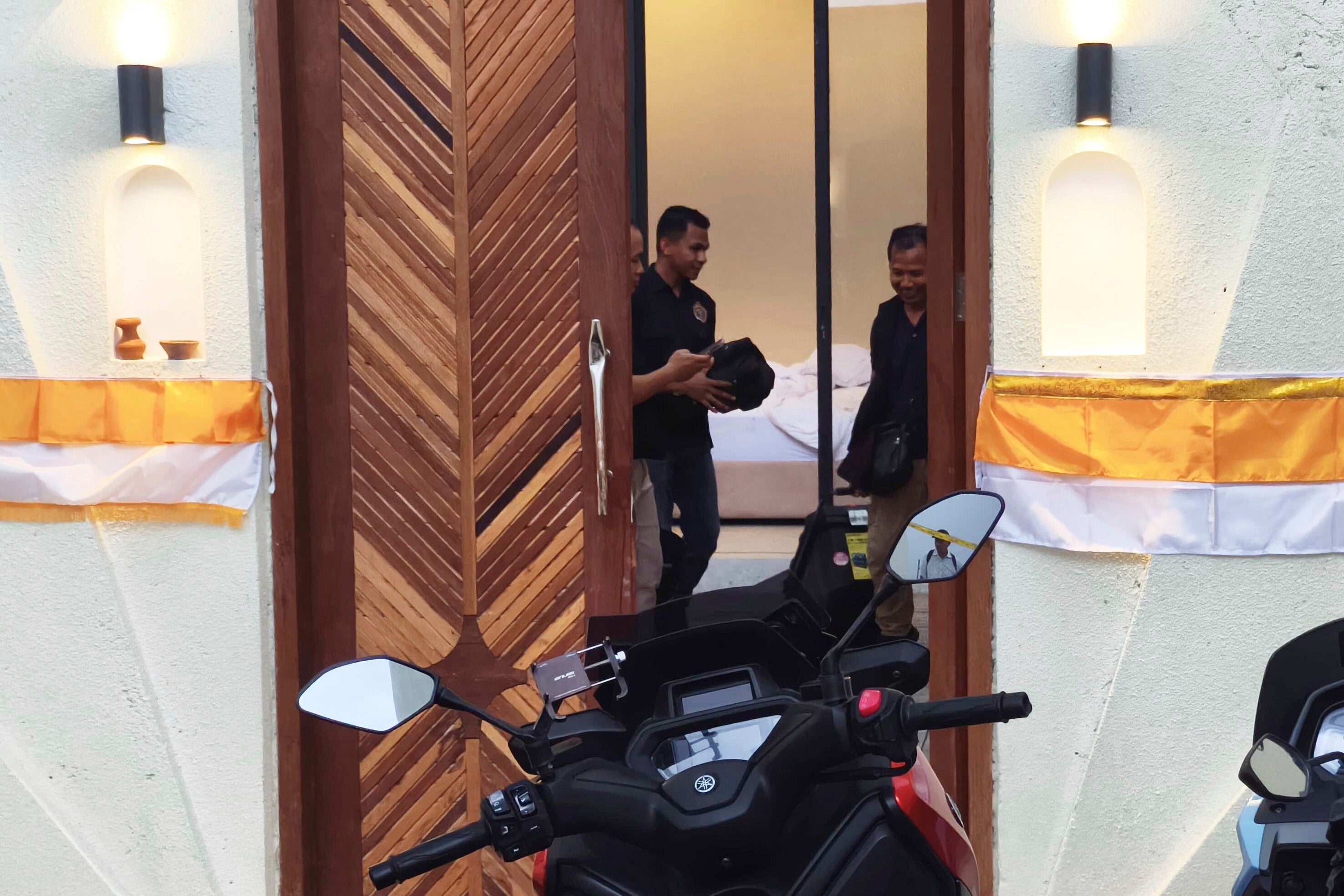 Police officers are seen inside a villa where the shooting occurred