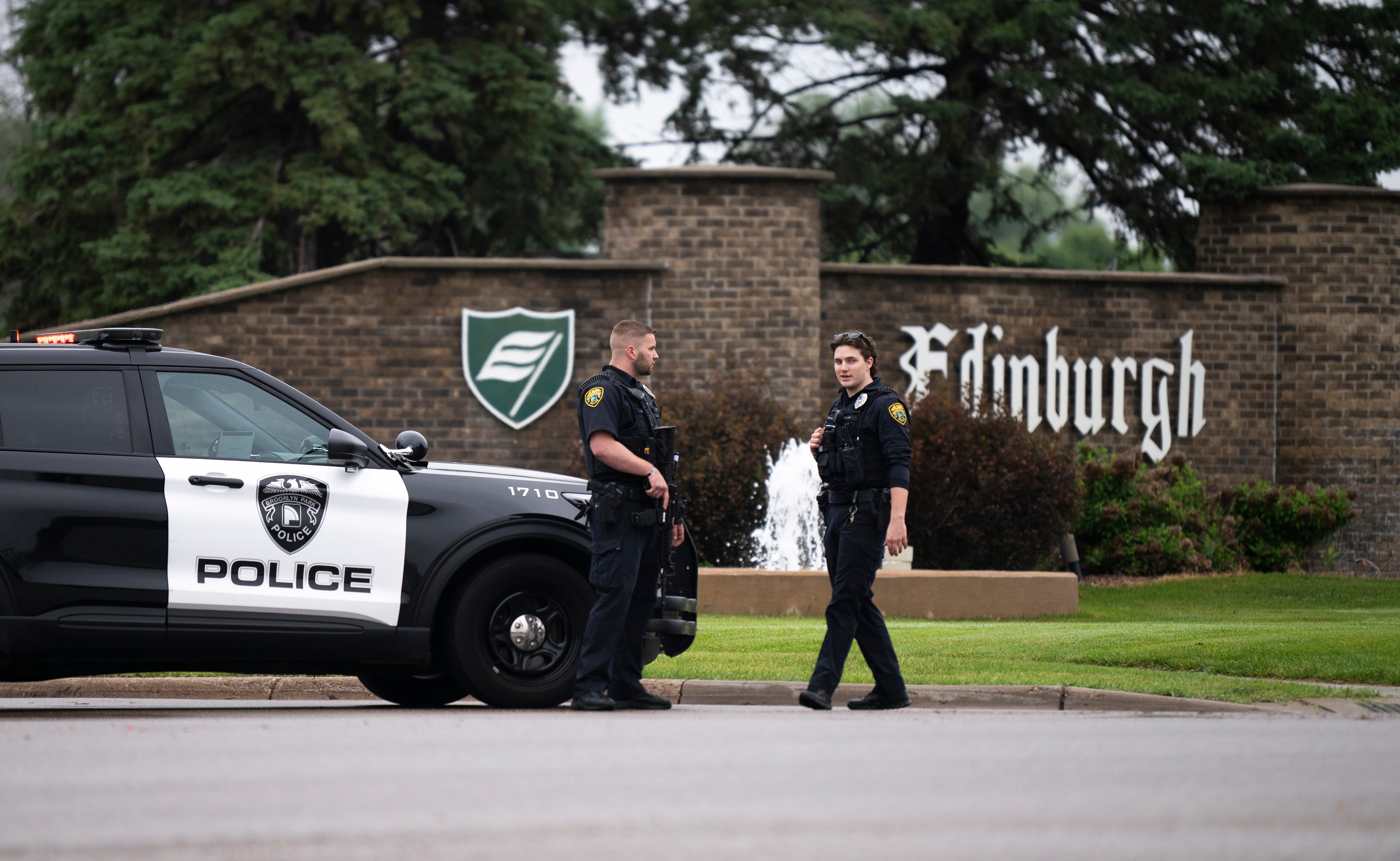 Brooklyn Park police officers speak with each other as they guard the entrance to a neighborhood on June 14.