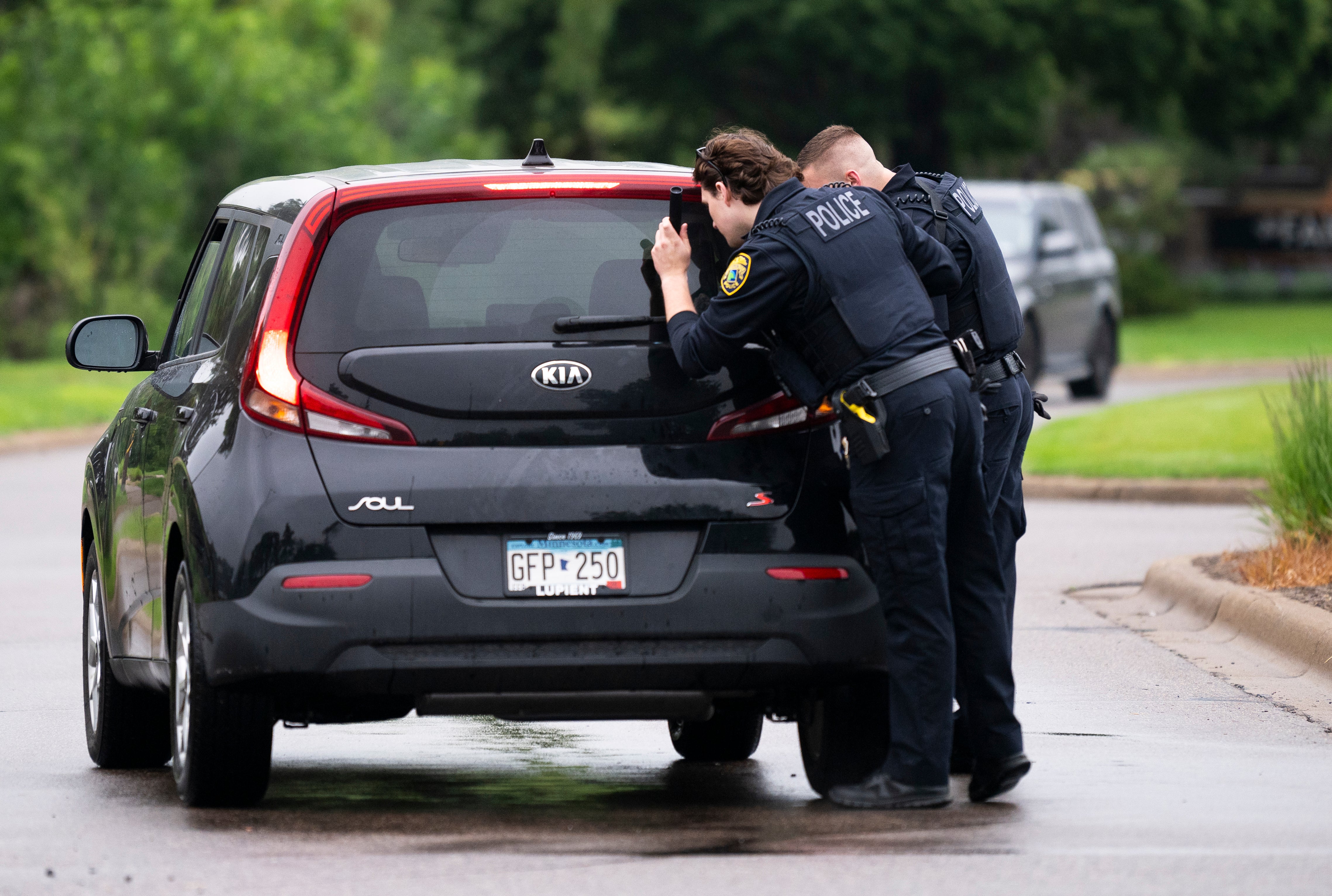Officers search a vehicle entering a neighborhood shortly after the shootings.