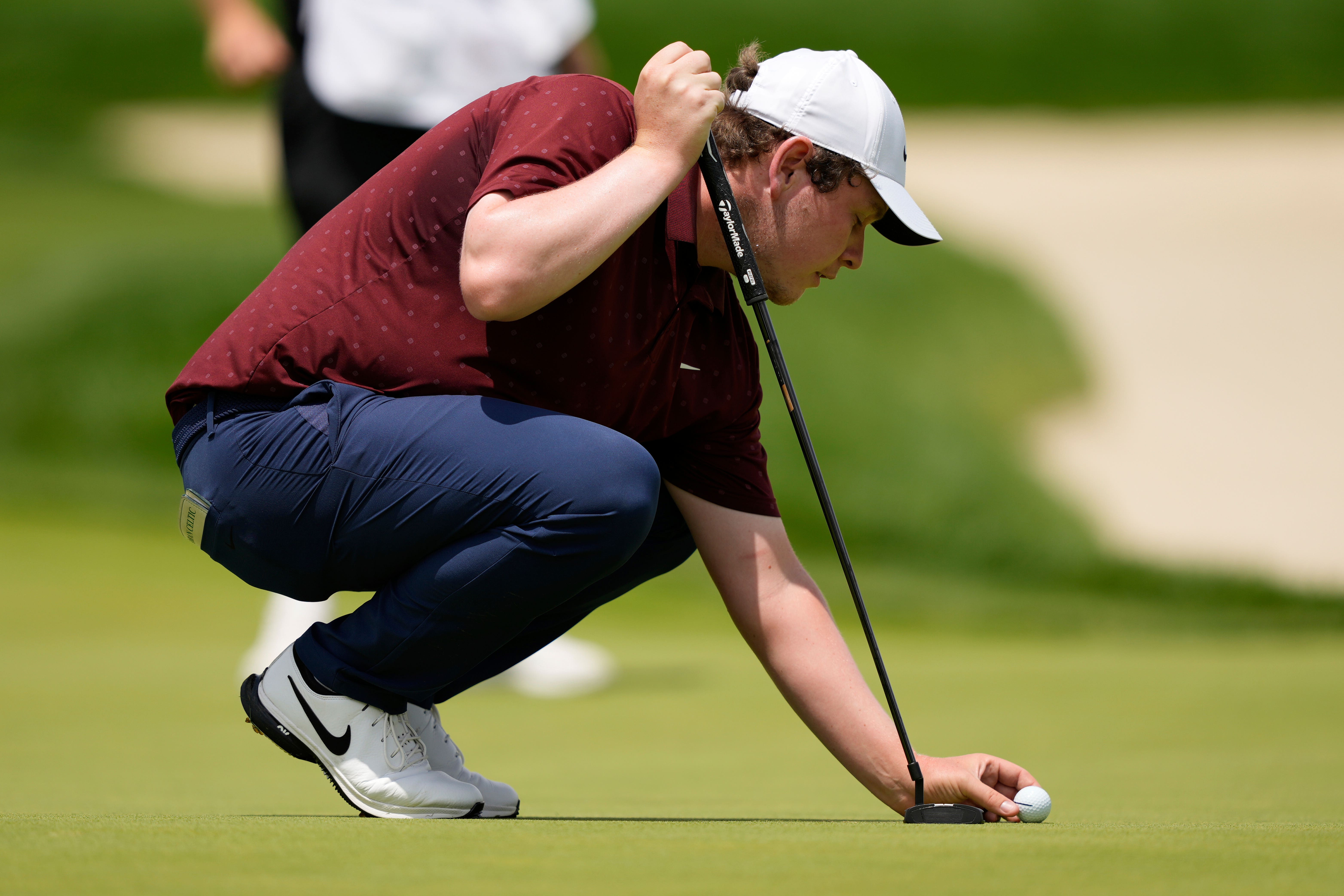 Robert MacIntyre, of Scotland, places his ball on the eight hole during the third round of the U.S. Open golf tournament at Oakmont Country Club Saturday, June 14, 2025, in Oakmont, Pa. (AP Photo/Carolyn Kaster)