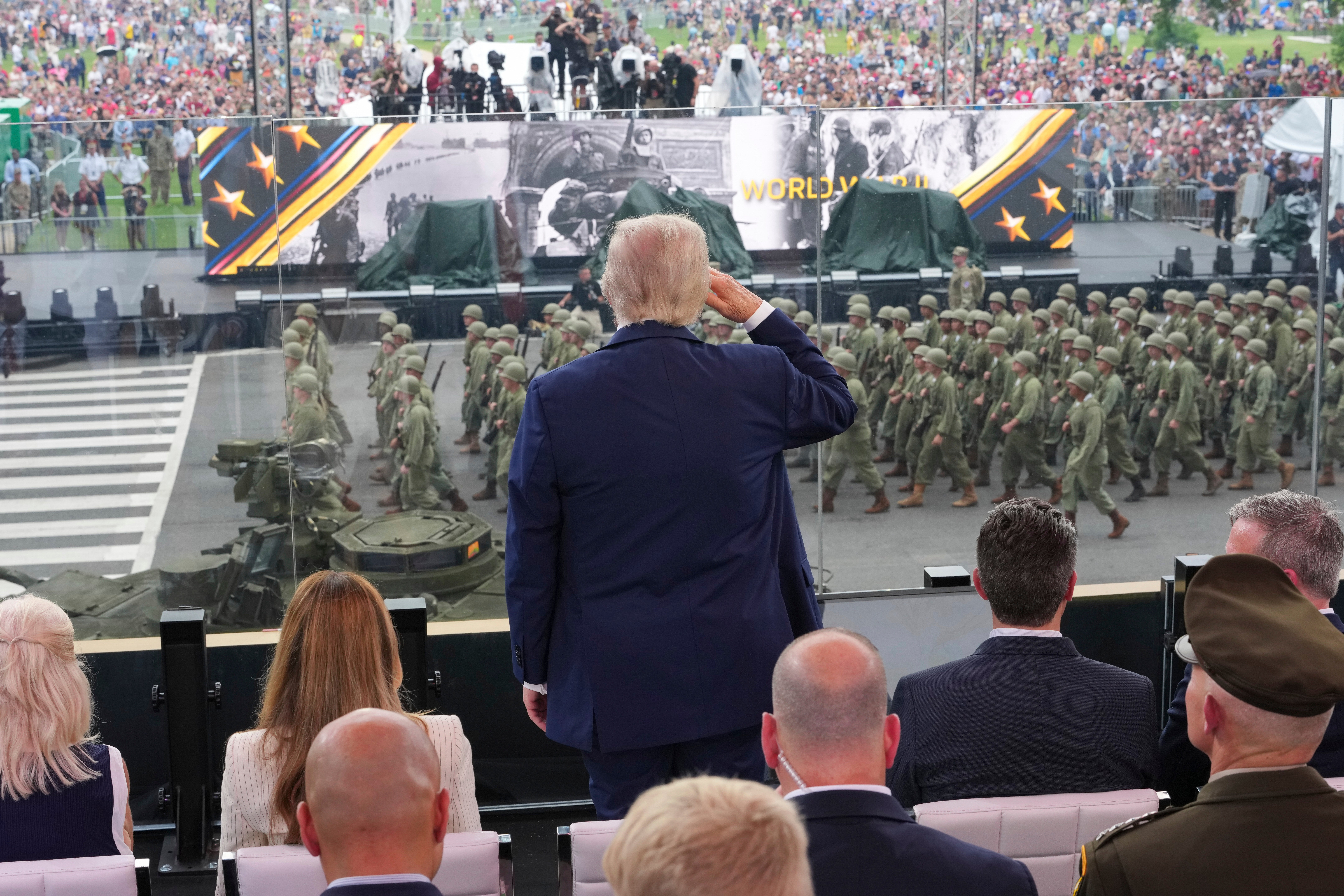 Trump salutes soldiers as they go by the viewing platform.