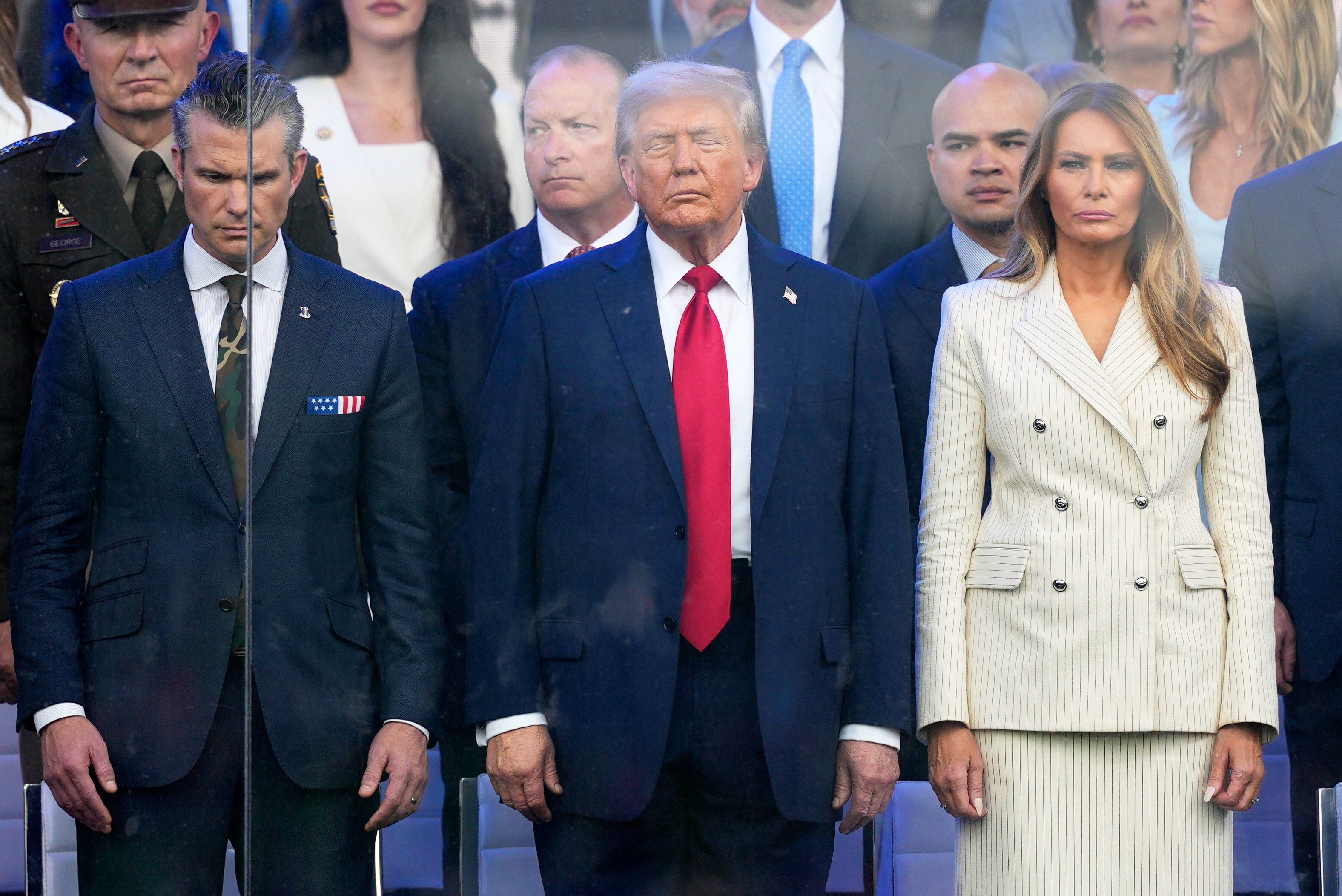 Trump, flanked by Defense Secretary Pete Hegseth and First Lady Melania Trump, watches the parade