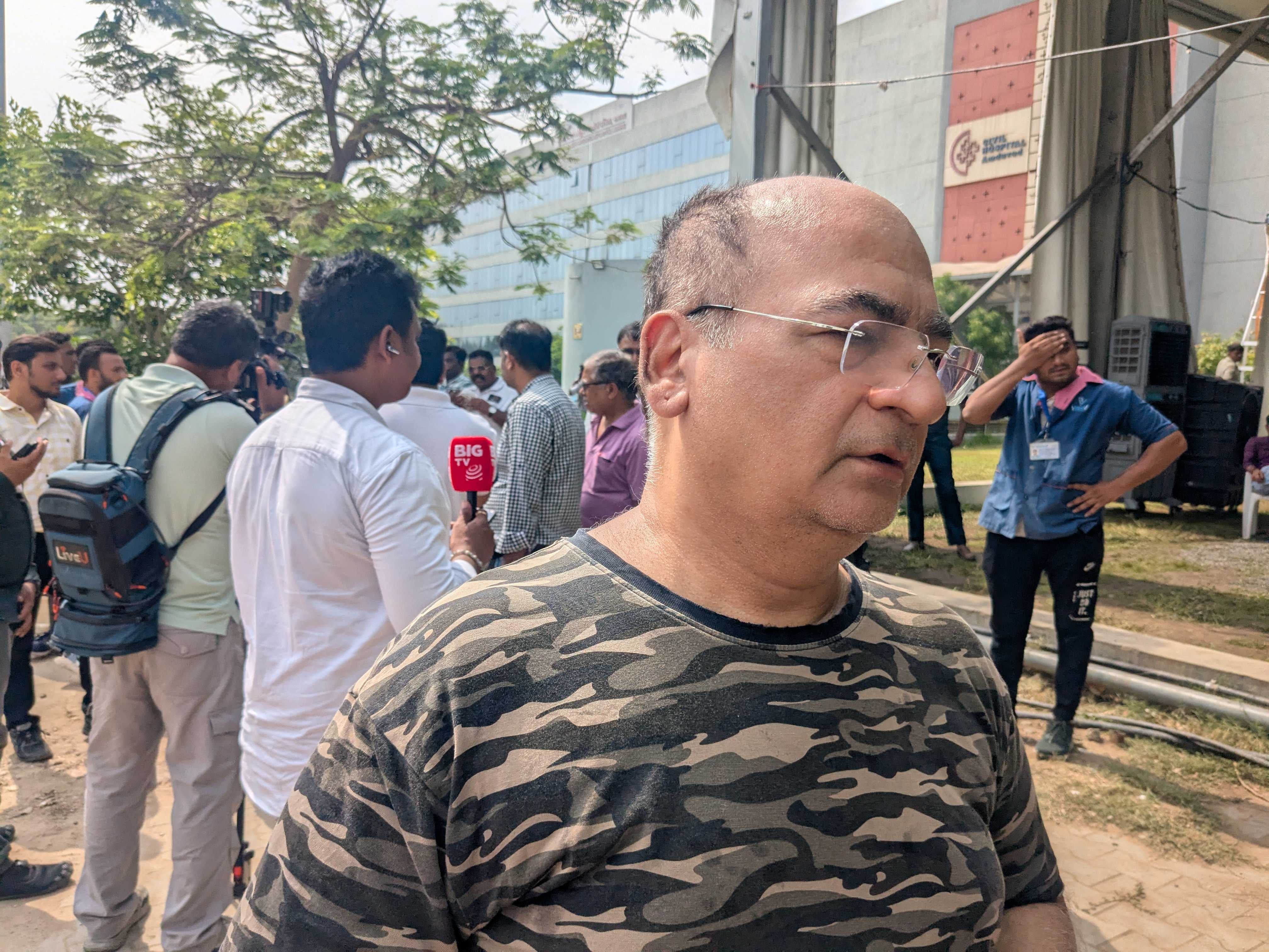 Kishore Rajpurohit waits outside the mortuary complex to receive mortal remains