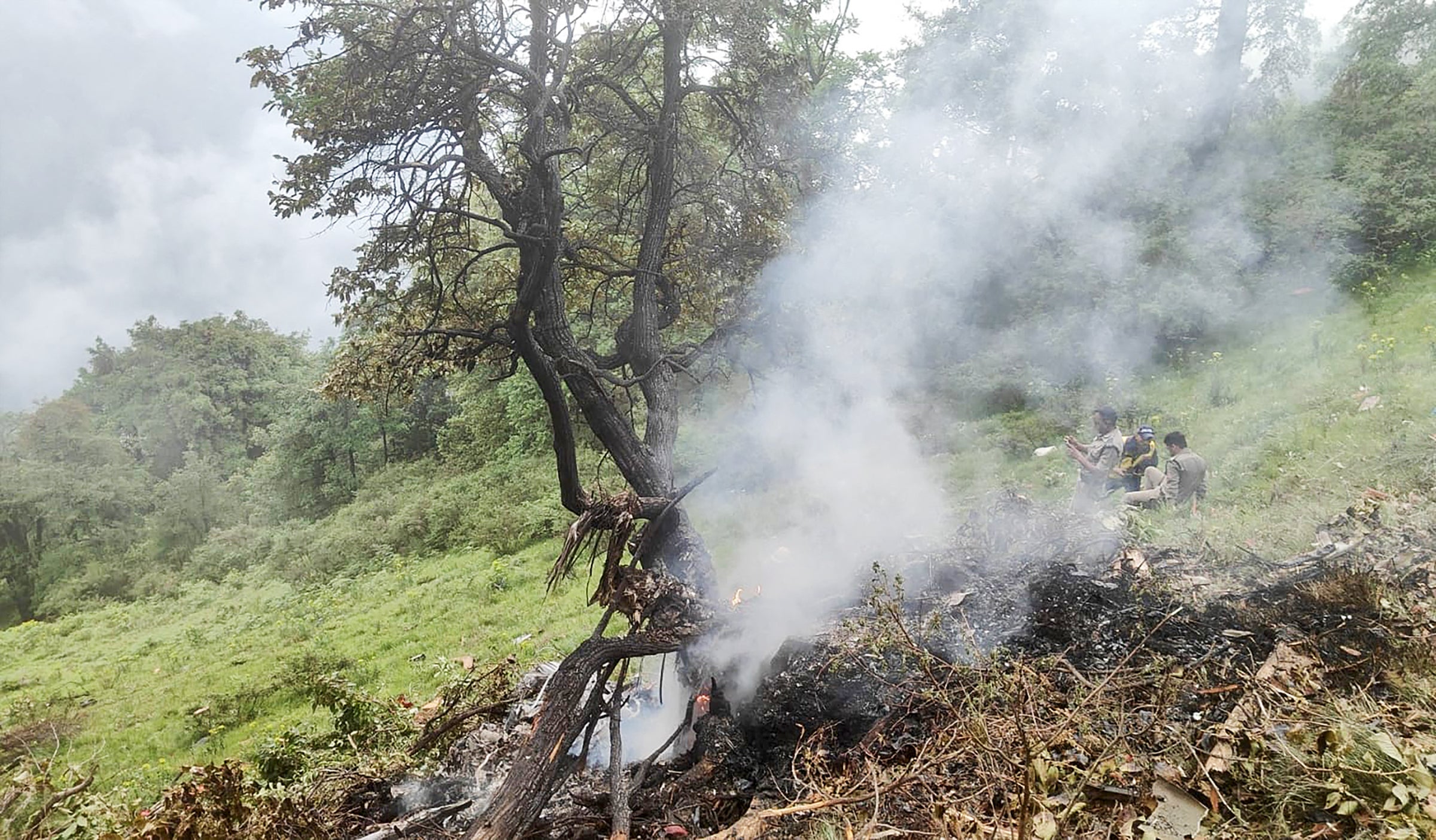 This handout photograph taken on 15 June 2025 and released by the State Disaster Response Force (SDRF) of India's Uttarakhand state shows smoke billowing from the site of a chopper crash near Gaurikund
