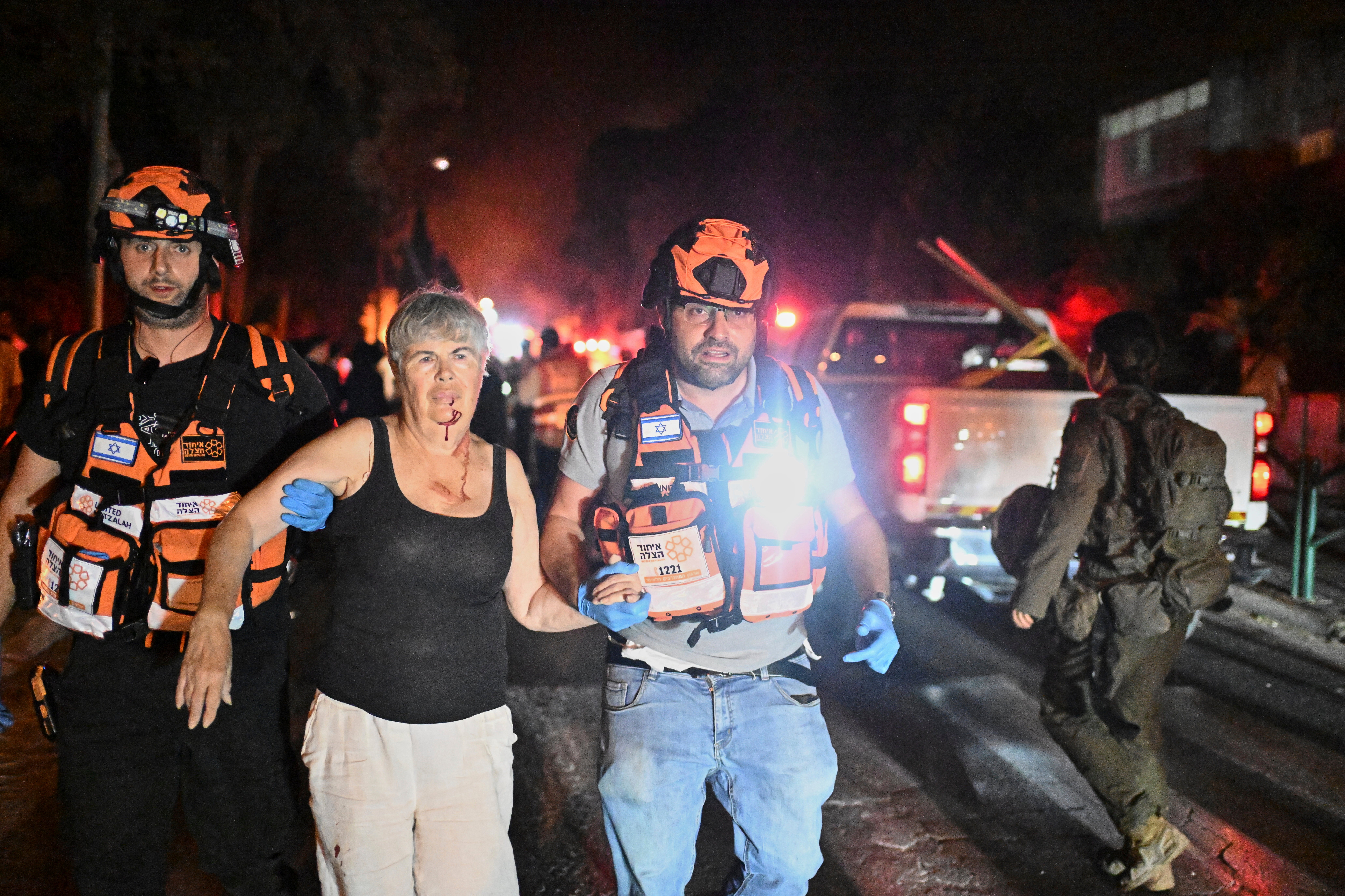 An Israeli rescue team evacuate a wounded woman from a site struck by a missile in Haifa