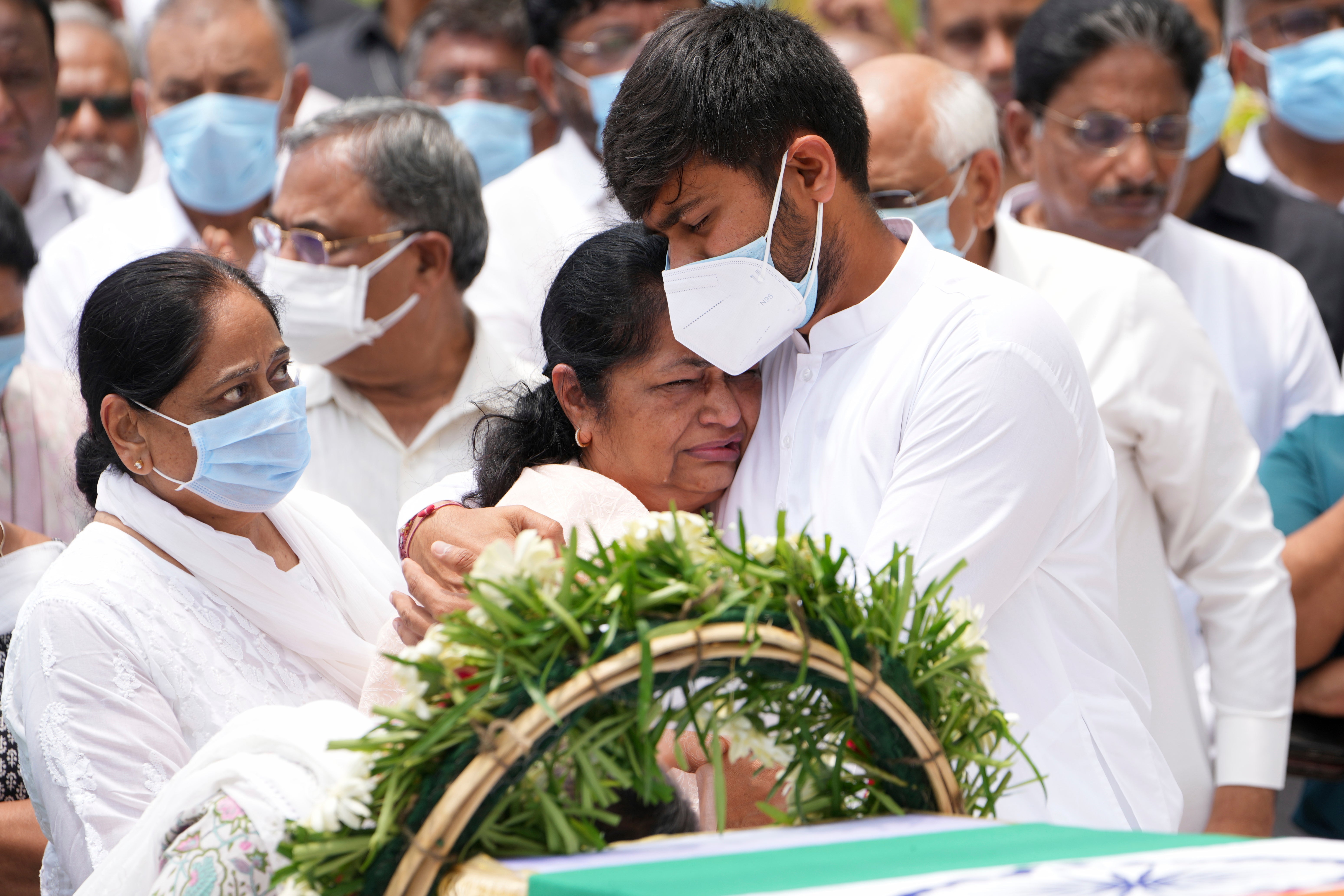 Rushabh Rupani, son of former Chief Minister of Gujarat Vijay Rupani, consoles his mother Anjali Rupani as they receive the body of Vijay Rupani, who died in Thursday's Air India plane crash