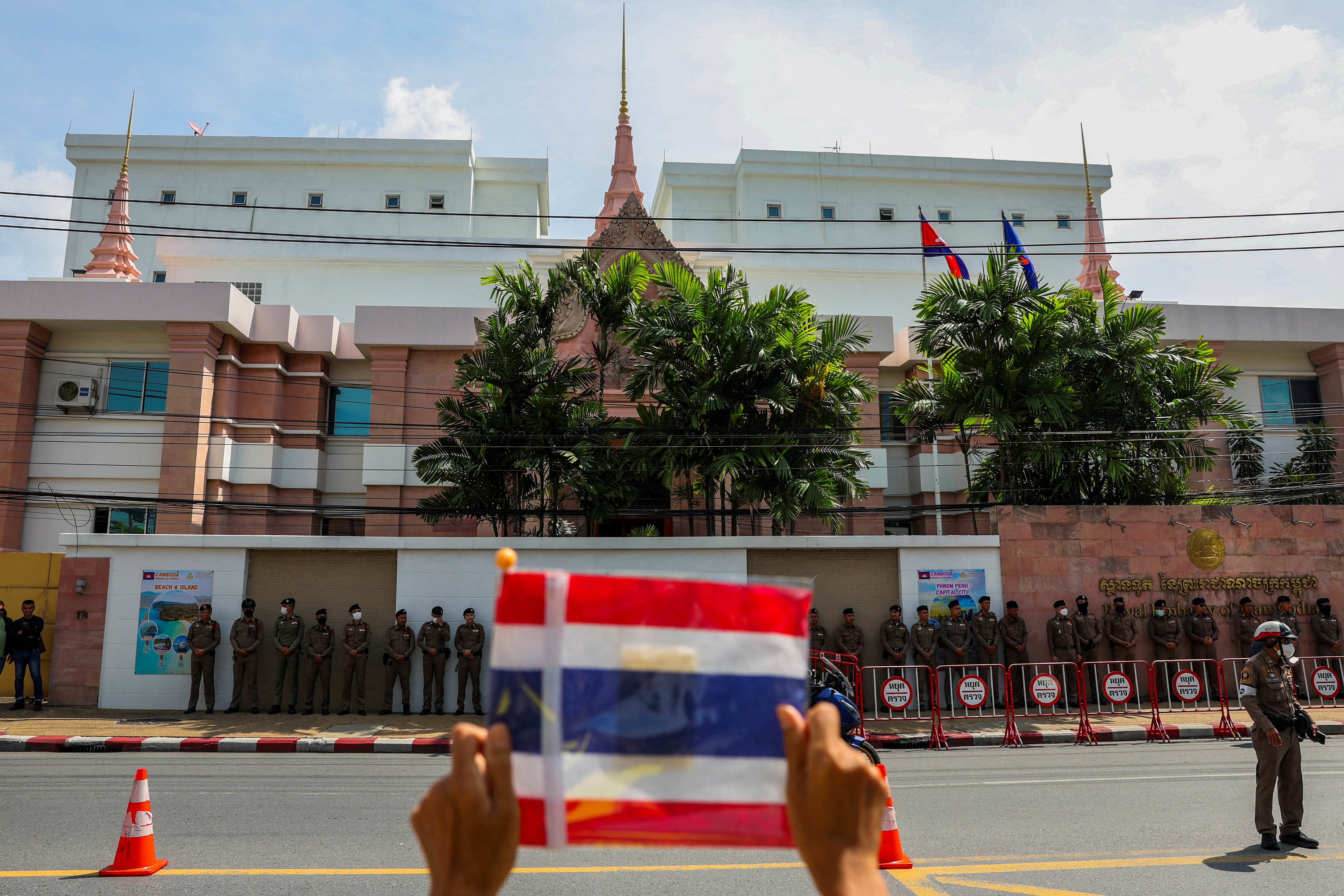 A royalist activist holds a Thai flag as he protests in front of the Royal Embassy of Cambodia