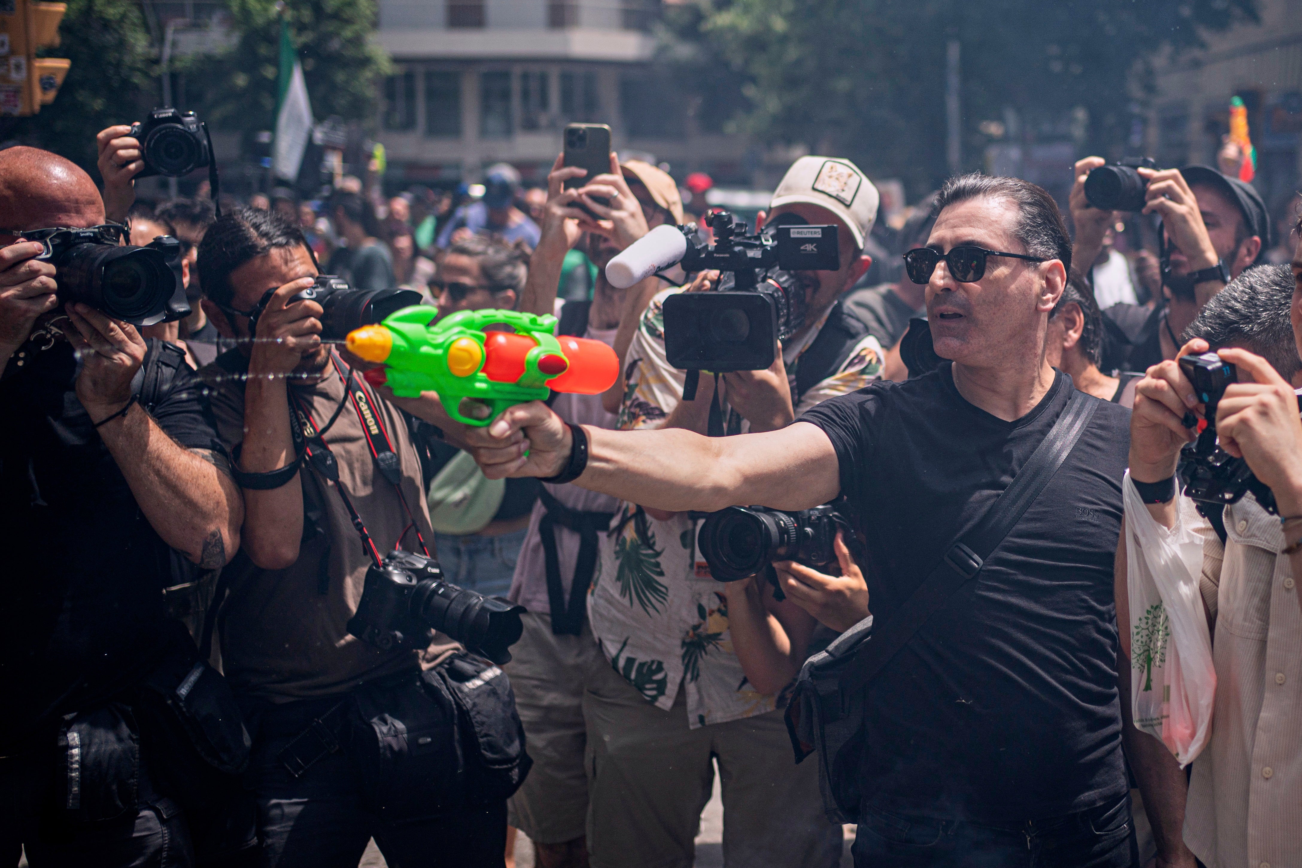 A protester holds a water gun during a protest against overtourism in Barcelona, Spain, Sunday, June 15, 2025. (AP Photo/Pau Venteo)