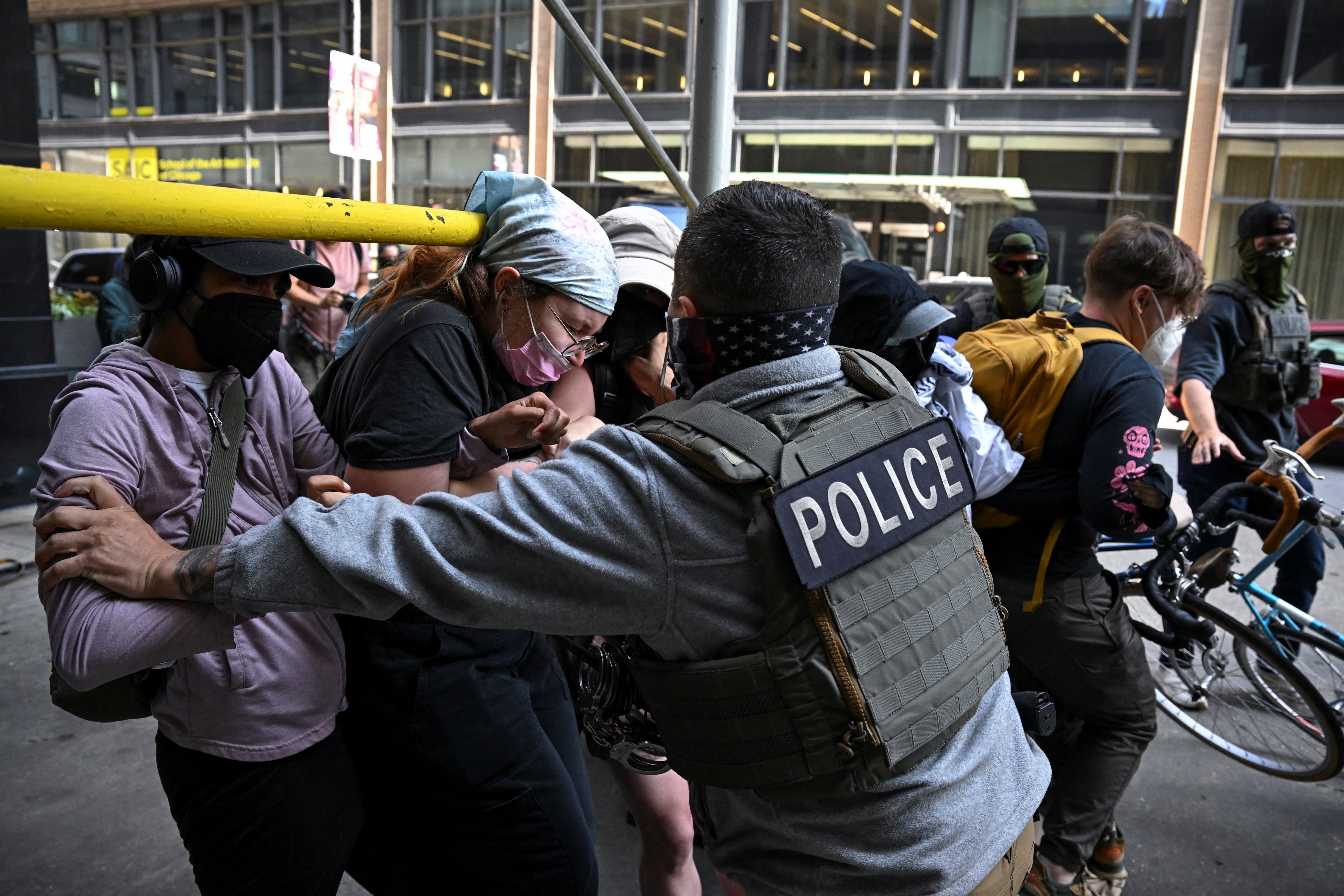 A police officer holds protesters as they block U.S. Immigration and Customs Enforcement (ICE) personnel from entering a building housing an immigration court amid federal immigration sweeps in Chicago, Illinois, U.S., June 16, 2025. REUTERS/Dylan Martinez