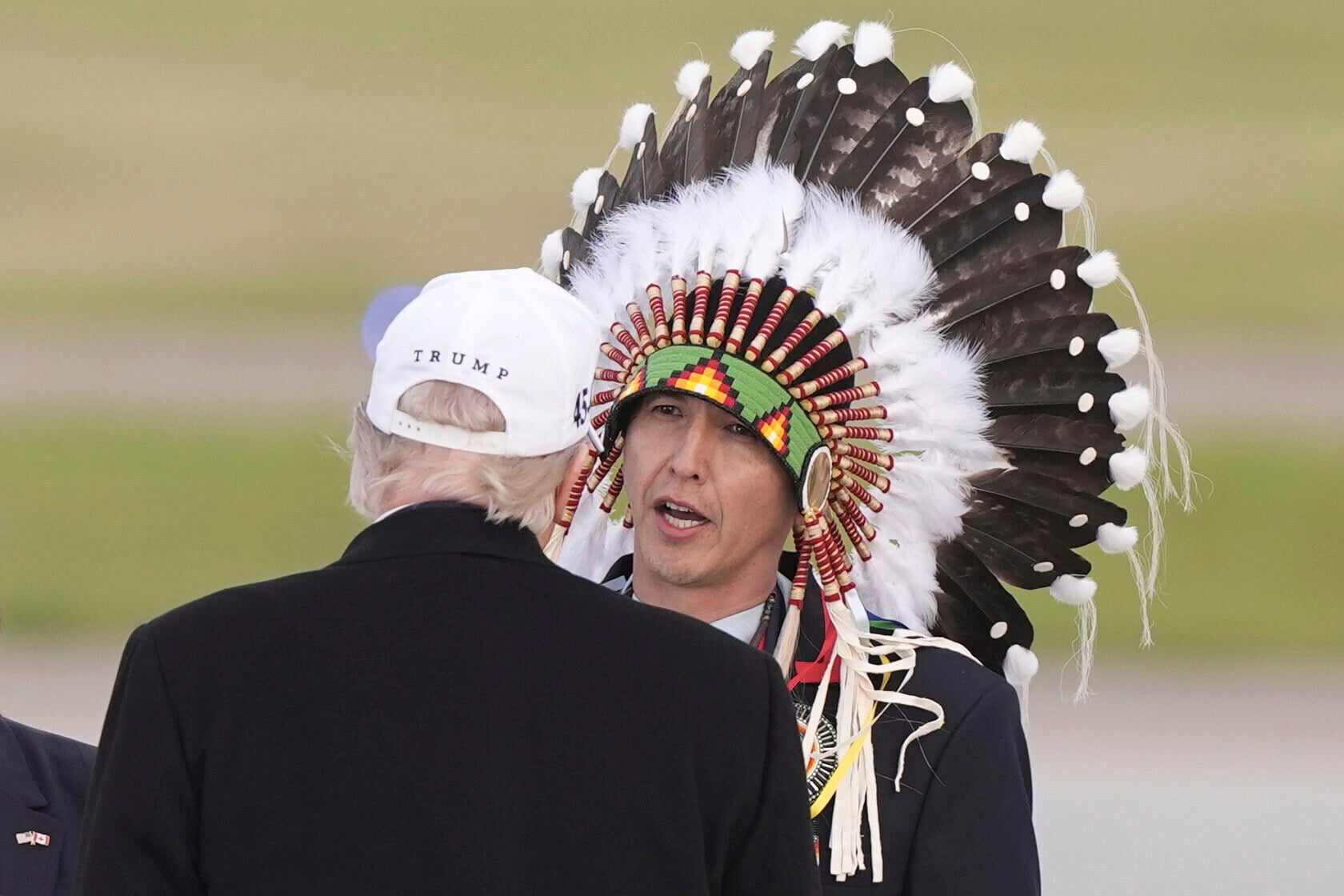 President Donald Trump is greeted by Steven Crowchild of the Tsuut'ina First Nation, as he arrives at Calgary International Airport, Sunday, June 15, 2025, in Calgary, Canada, ahead of the G7 Summit. (AP Photo/Gerald Herbert)