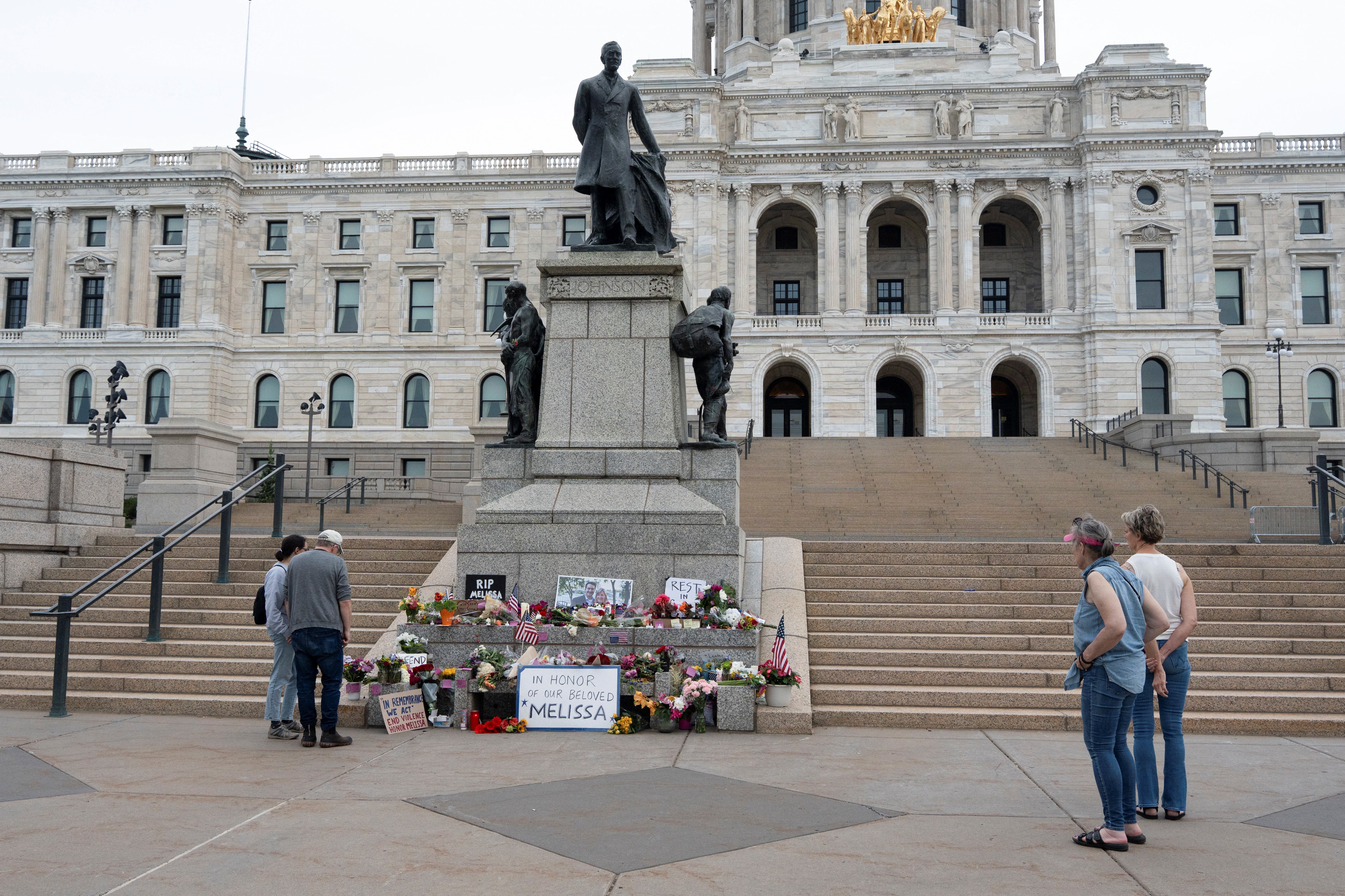 People visit a memorial outside the Minnesota State Capitol in honor of Democratic state assemblywoman Melissa Hortman and her husband Mark, after a gunman killed them on Saturday