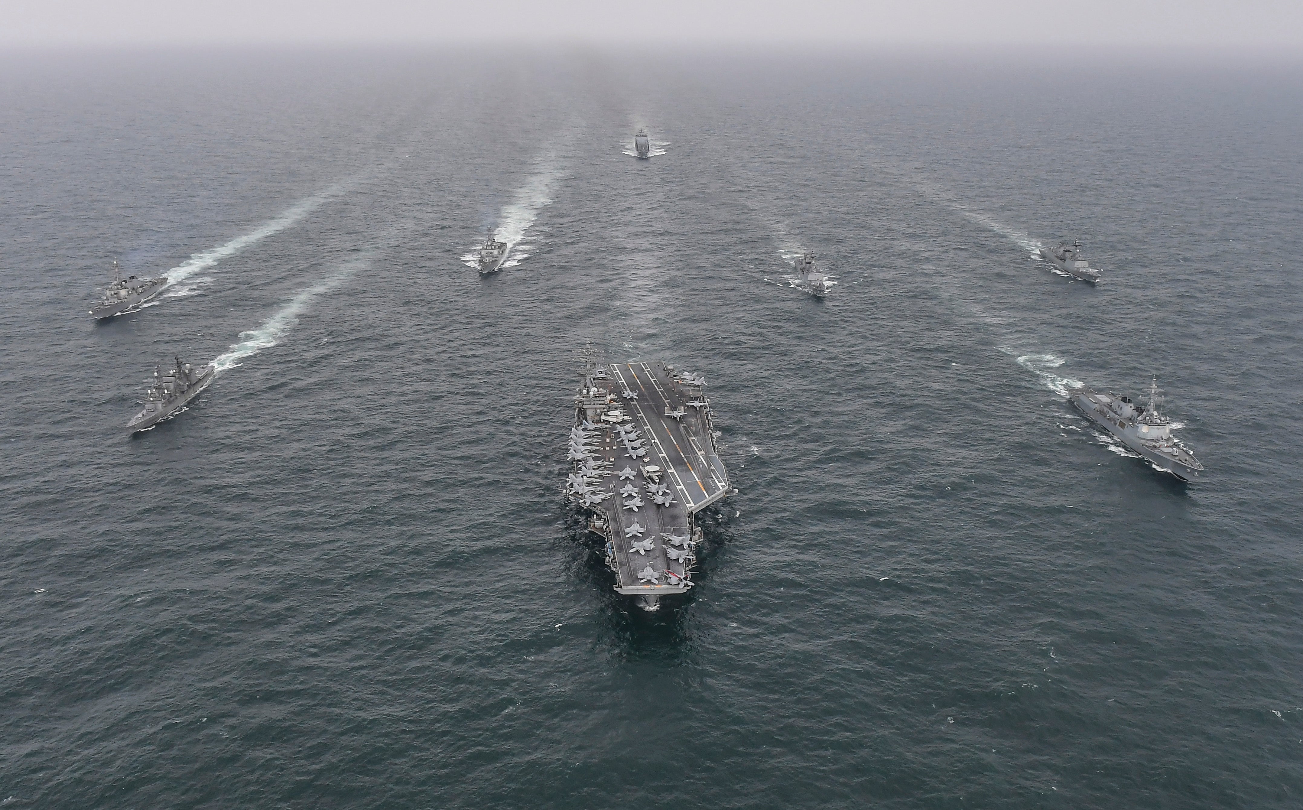 <p>The USS Nimitz (center) sails through international waters alongside Japanese and South Korean ships during an exercise in April 2023</p>