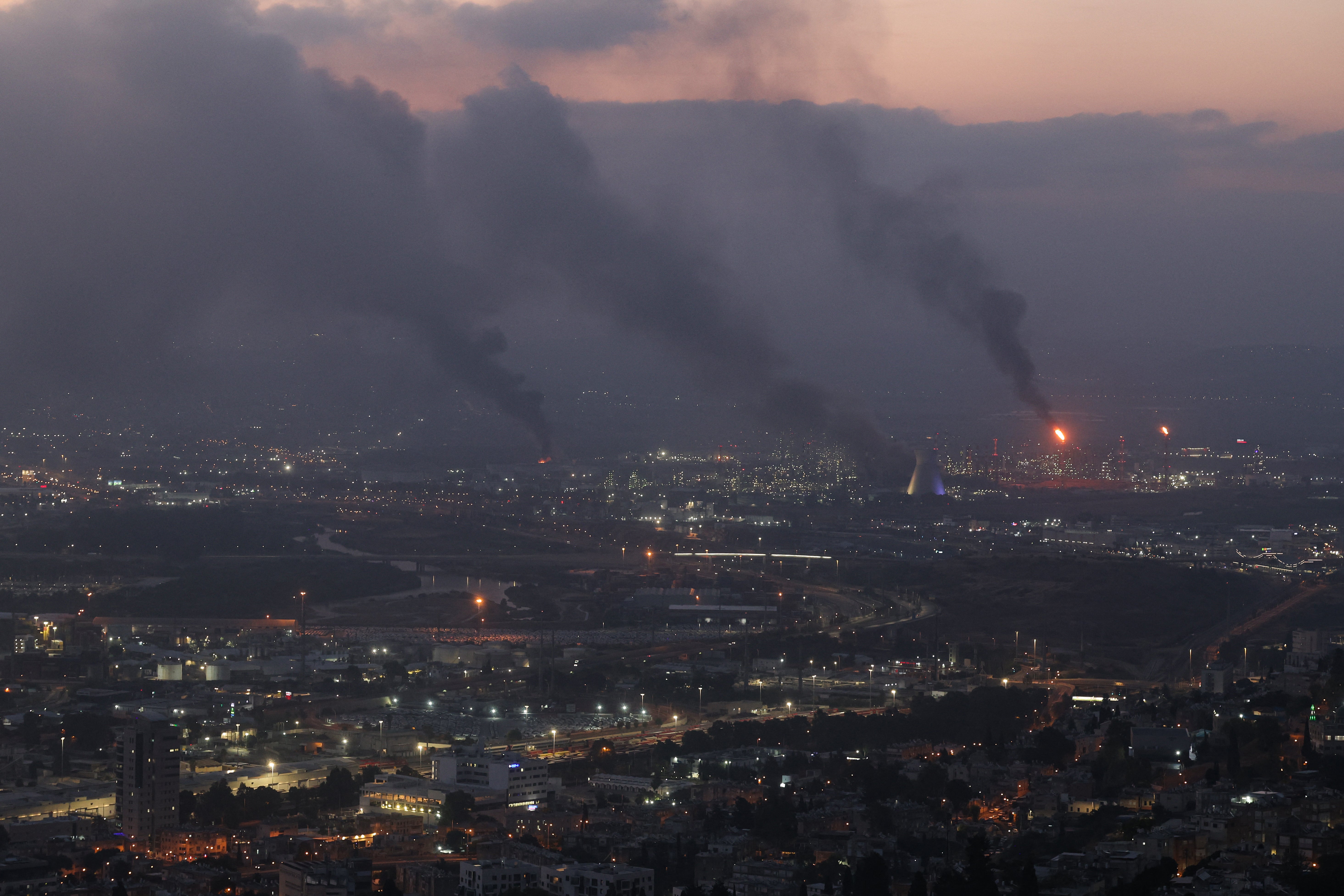 Smoke billows from buildings struck in Haifa after the dawn missile attack on the northern city on Monday by Iran. Lisa Baker and her daughter and mother are stranded in a hotel in the city