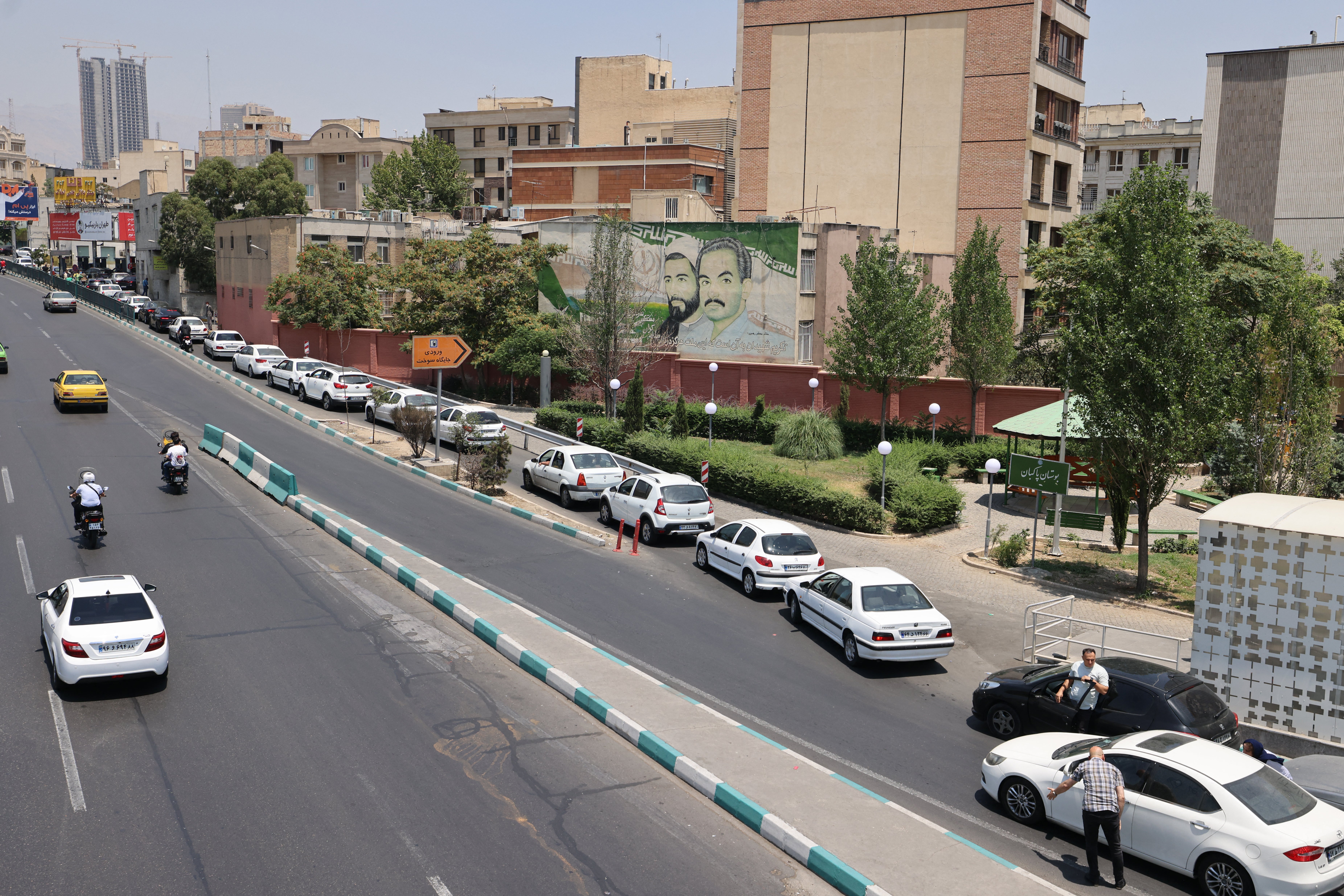 Iranians wait in the heat for hours to refuel their cars