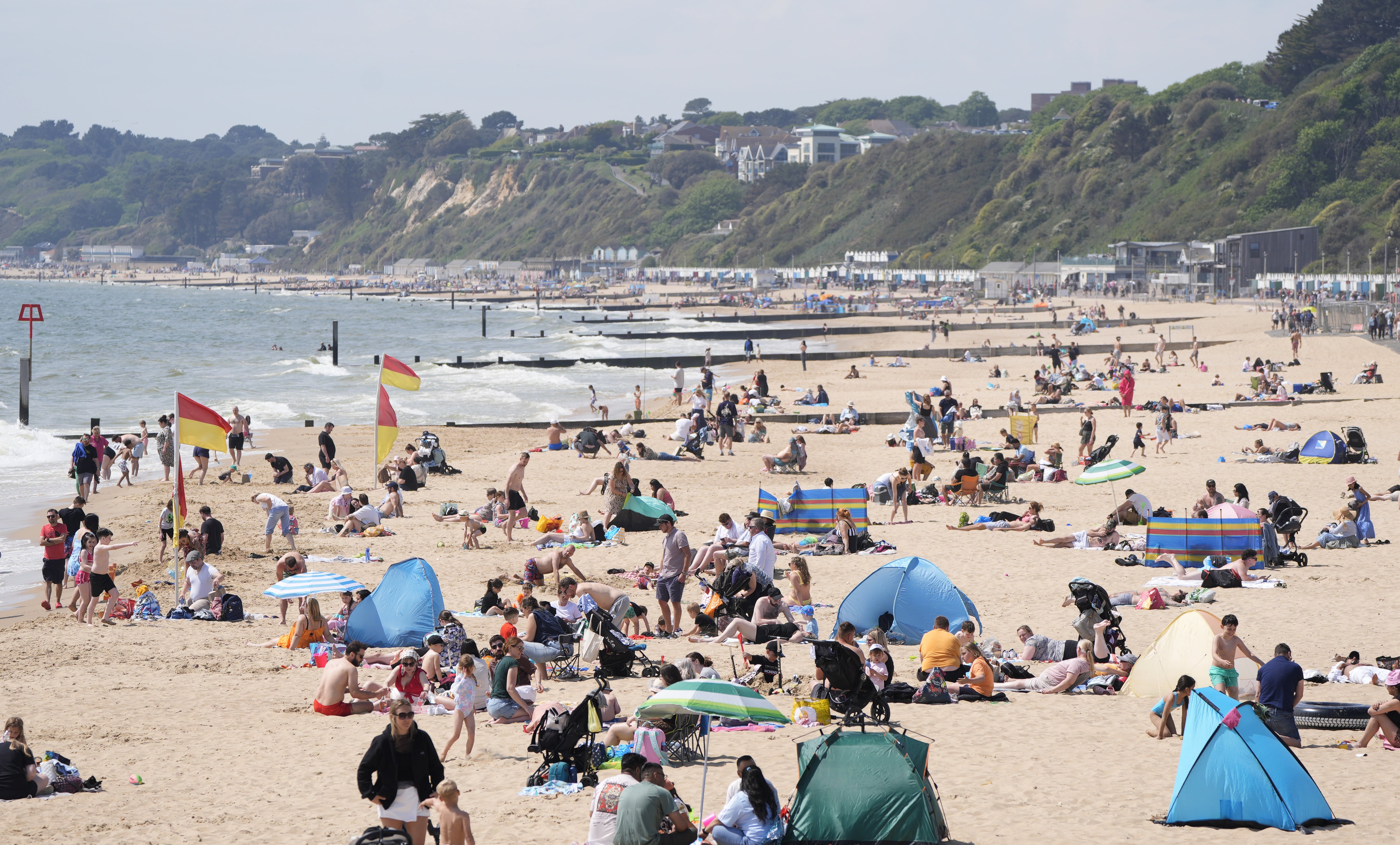 People enjoy the warm weather on Bournemouth Beach in Dorset (PA)