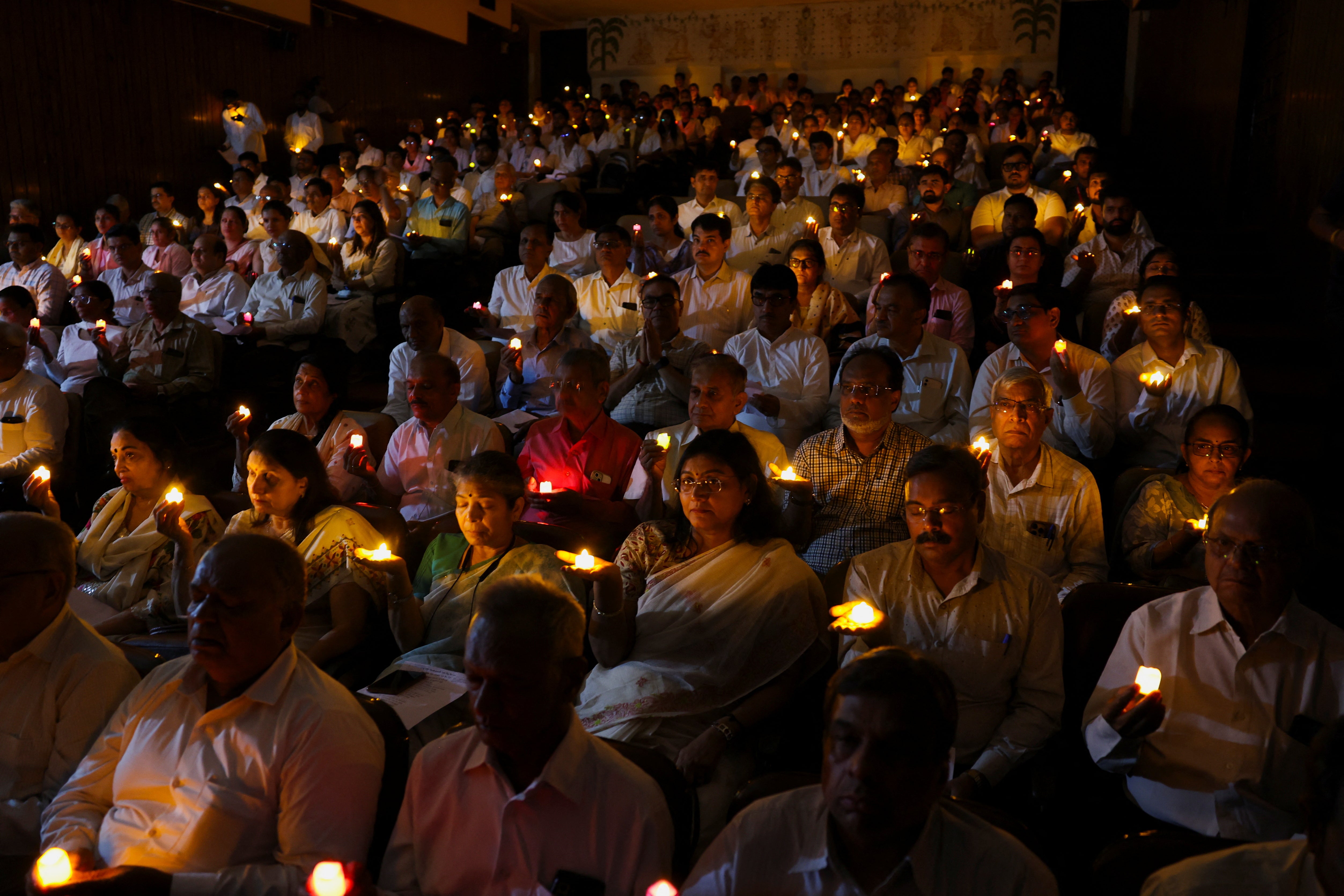 People hold candles as they take part in a special prayer ceremony for the victims of an Air India Boeing 787-8 Dreamliner plane, which crashed during take-off from an airport, in Ahmedabad, India, 17 June