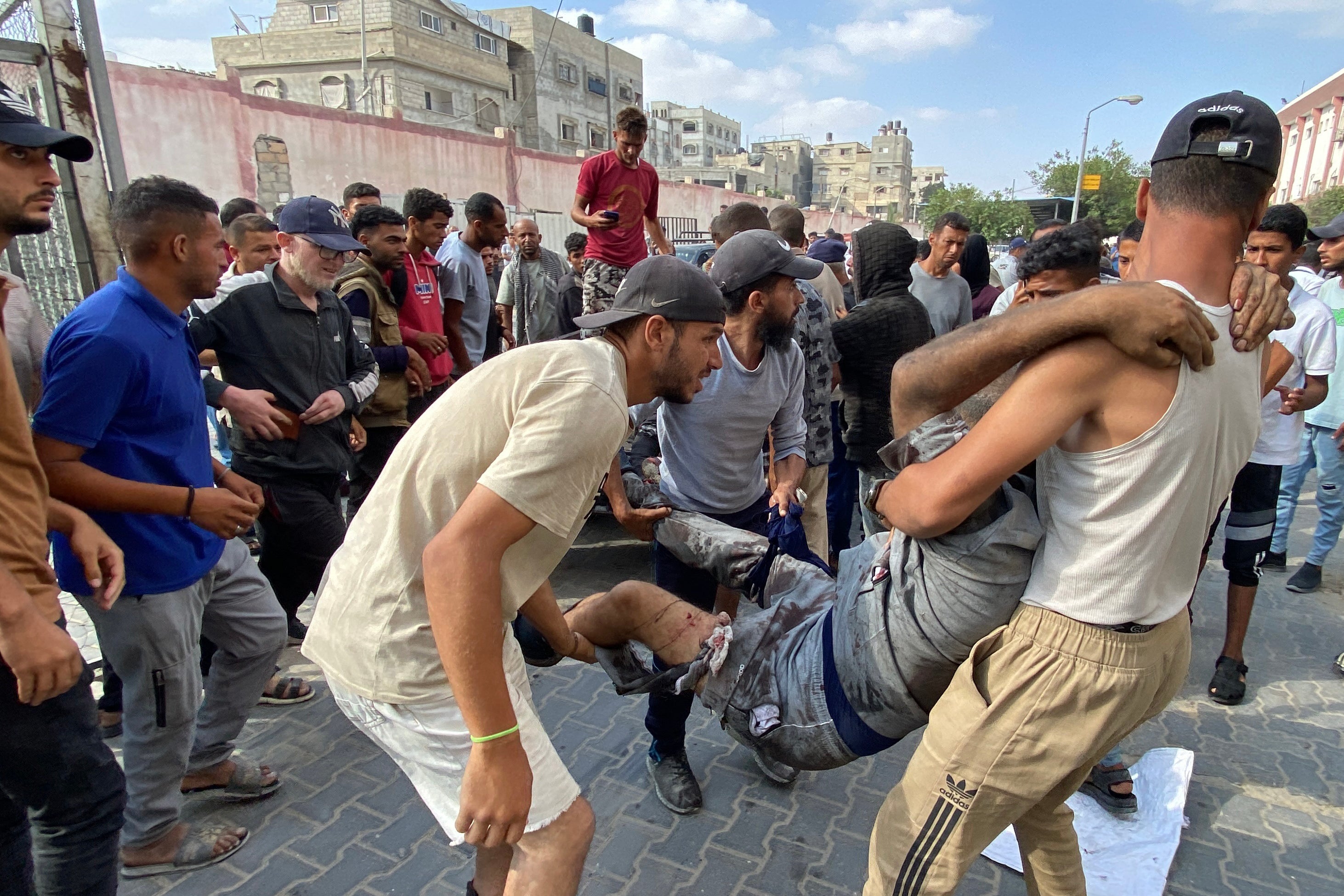 Palestinians transport a man who was shot by Israeli troops while waiting near a food aid centre