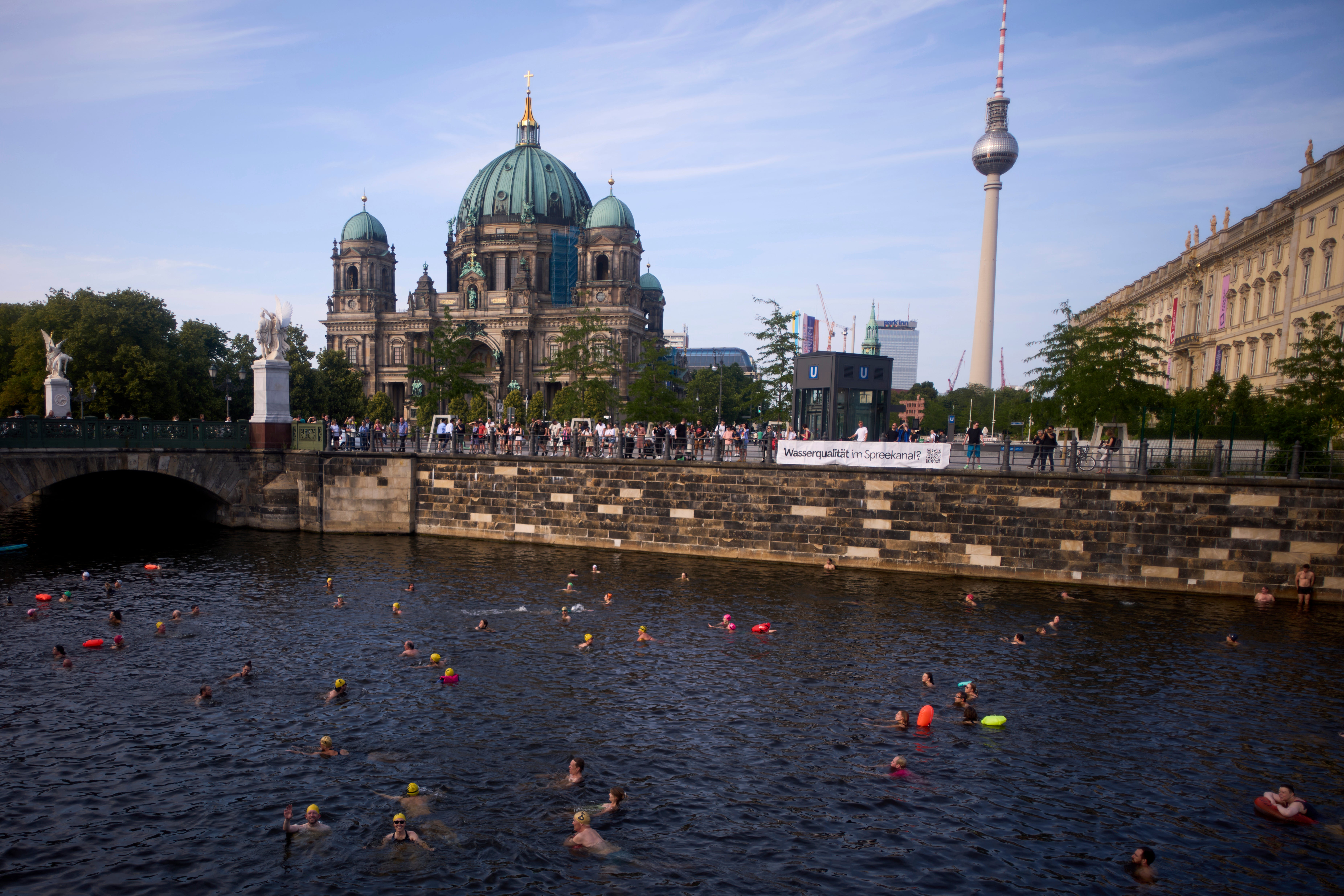 People swim in the river Spree to demand the lift of the hundred years old swimming ban at the river in front of the Berlin Cathedral and the TV Tower in Berlin, Germany, Tuesday, June 17, 2025. (AP Photo/Markus Schreiber)