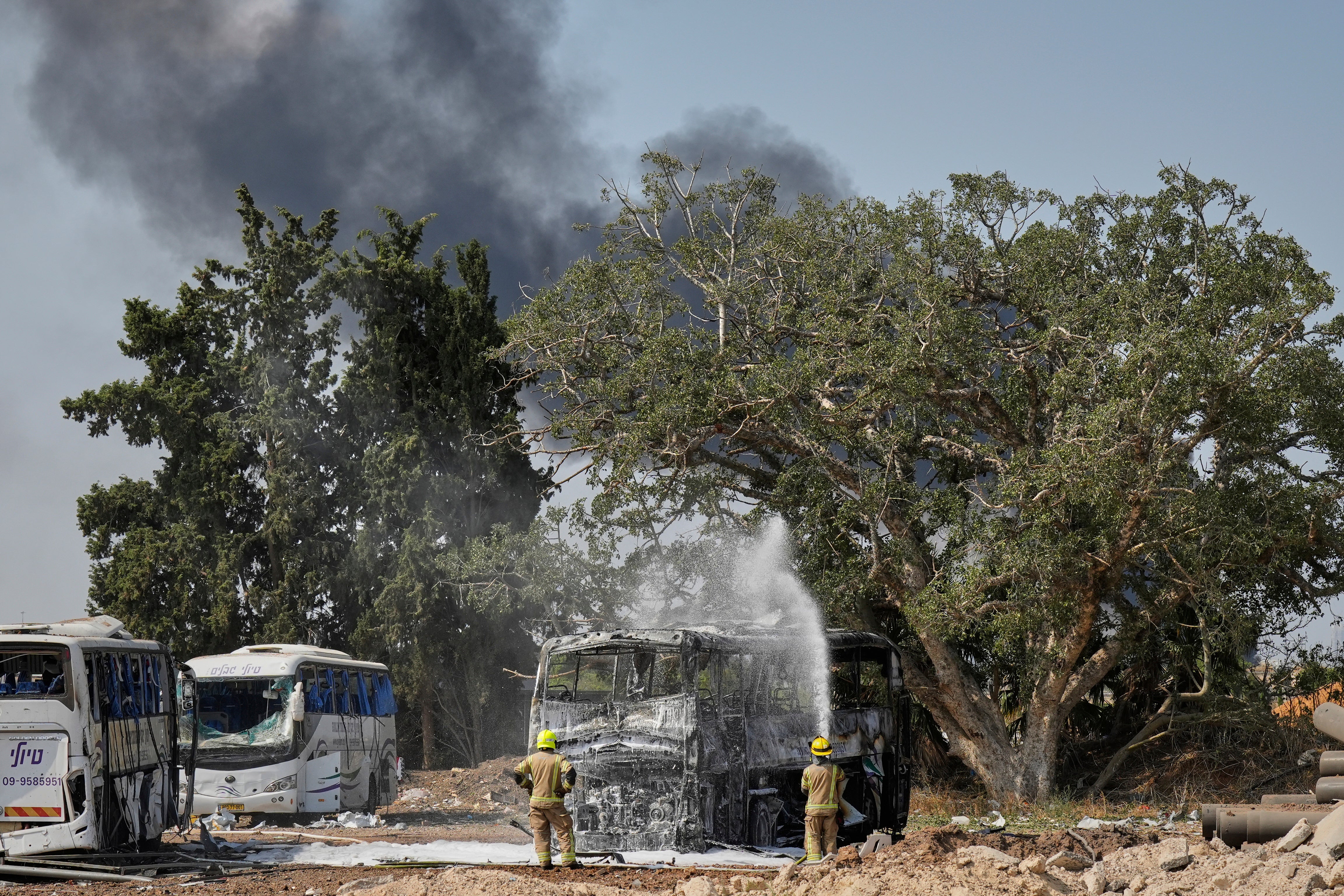 Firefighters work at the site of an Iranian missile strike in central Israel