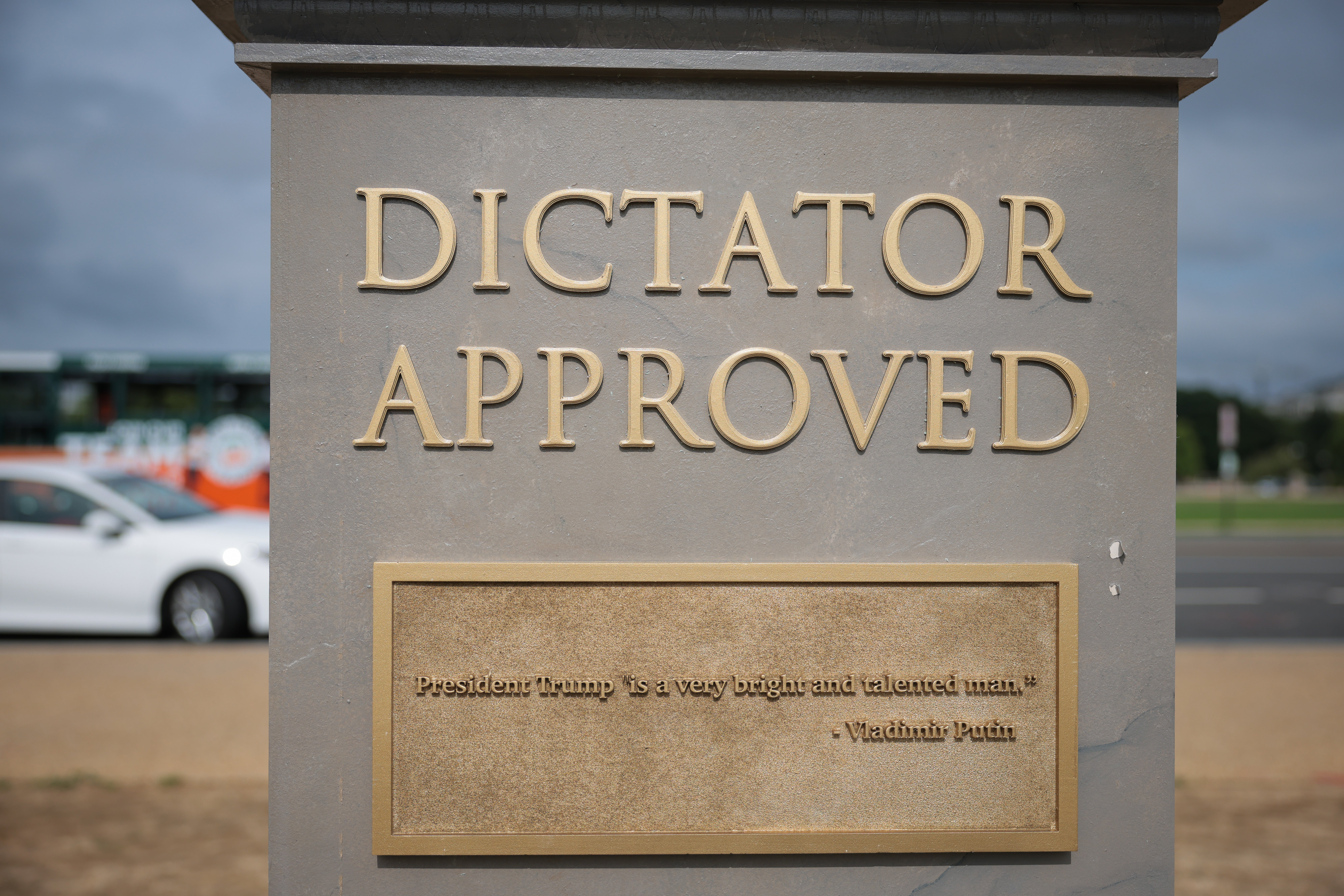 A quote from Vladimir Putin praising Trump is seen on one side of the pedestal of the sculpture.