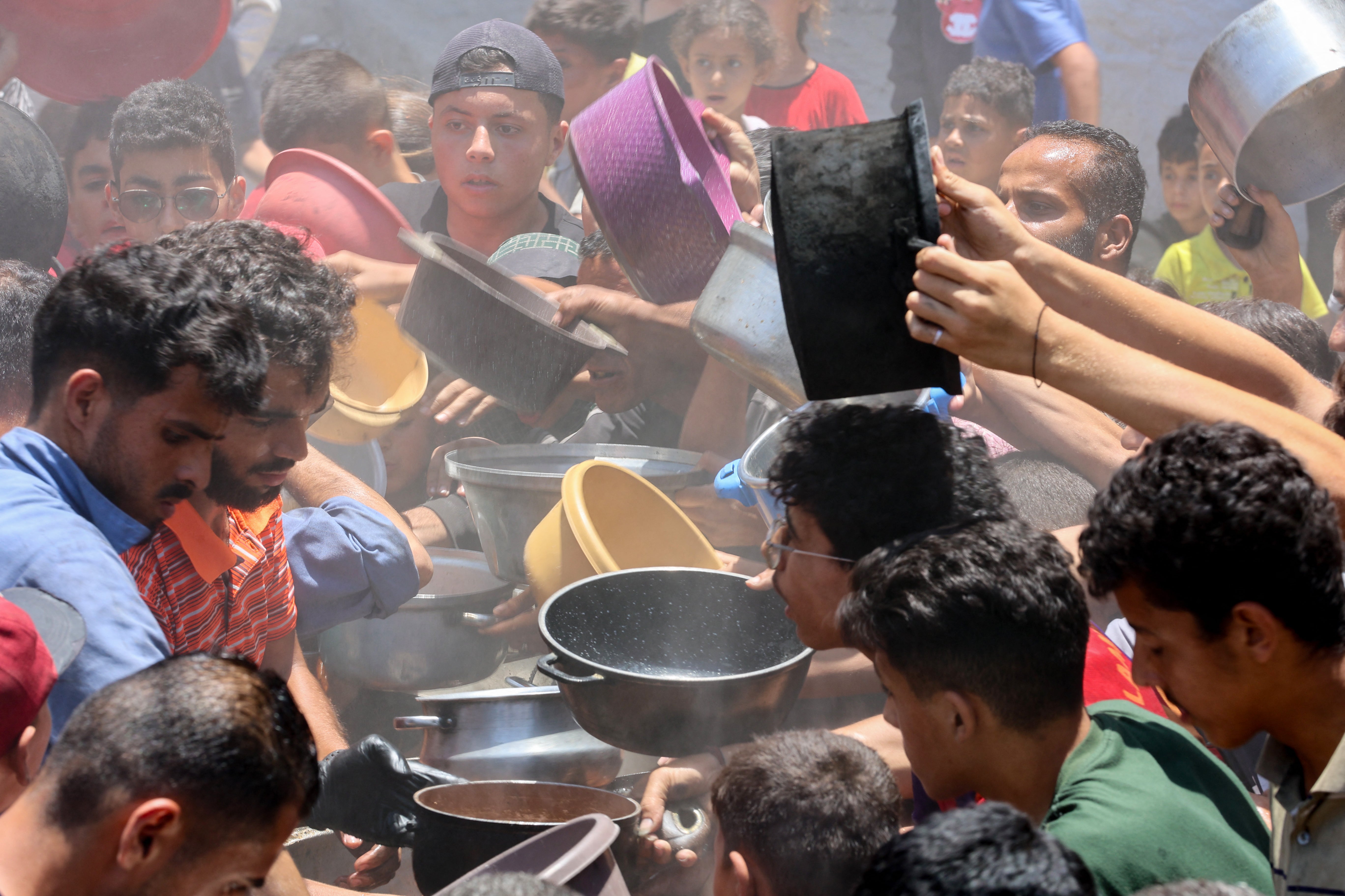 Palestinians try to get food at a charity kitchen in Rimal, Gaza City on Wednesday