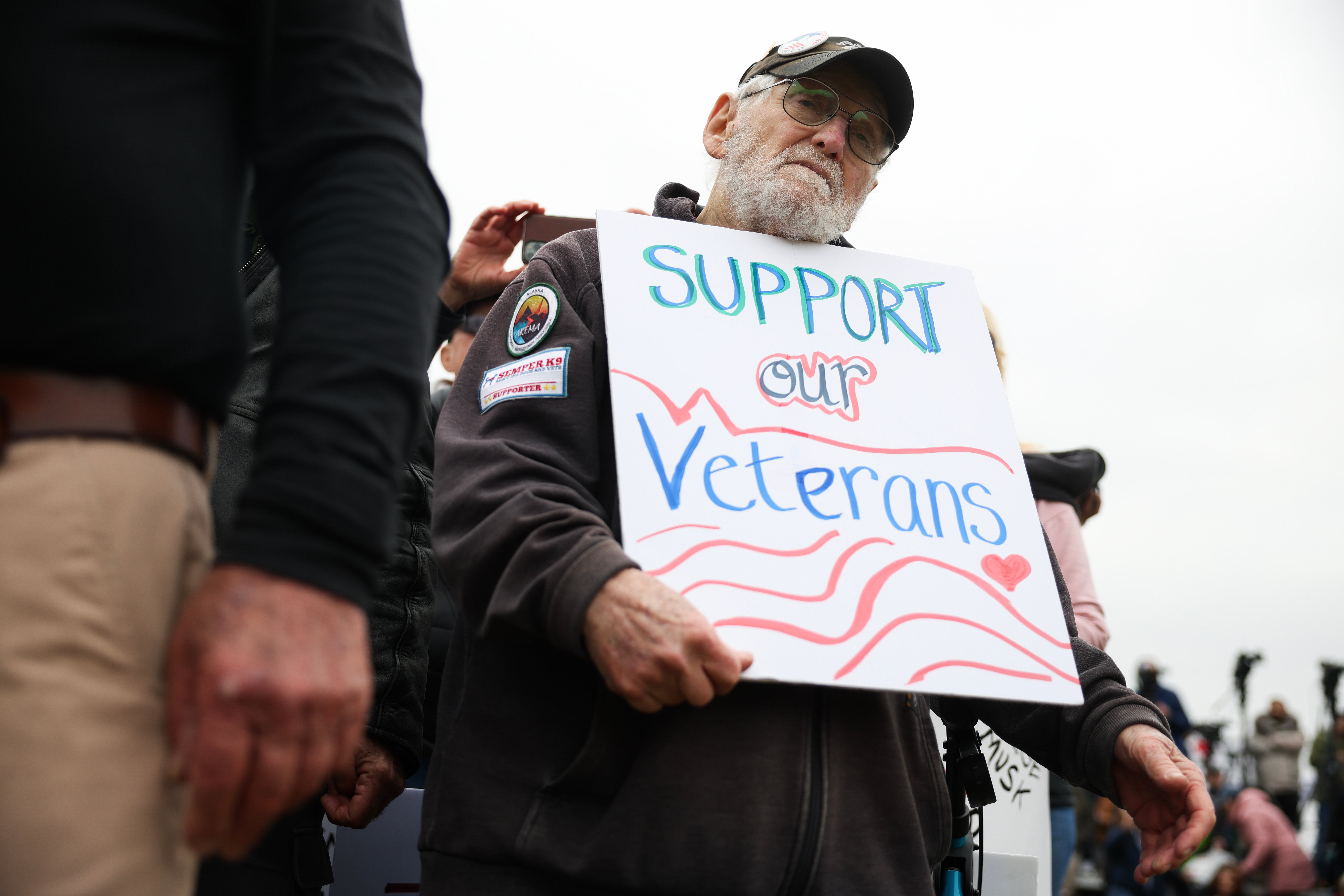 John Spitzberg, 87 holds a ‘Support our Veterans’ sign during a ‘Veterans March’ at the National Mall on March 14, 2025 in Washington, D.C. Spitzberg was arrested outside the U.S. Capitol on June 13 during a veteran’s protest against President Donald Trump’s military parade and National Guard deployment to crush anti-ICE protests