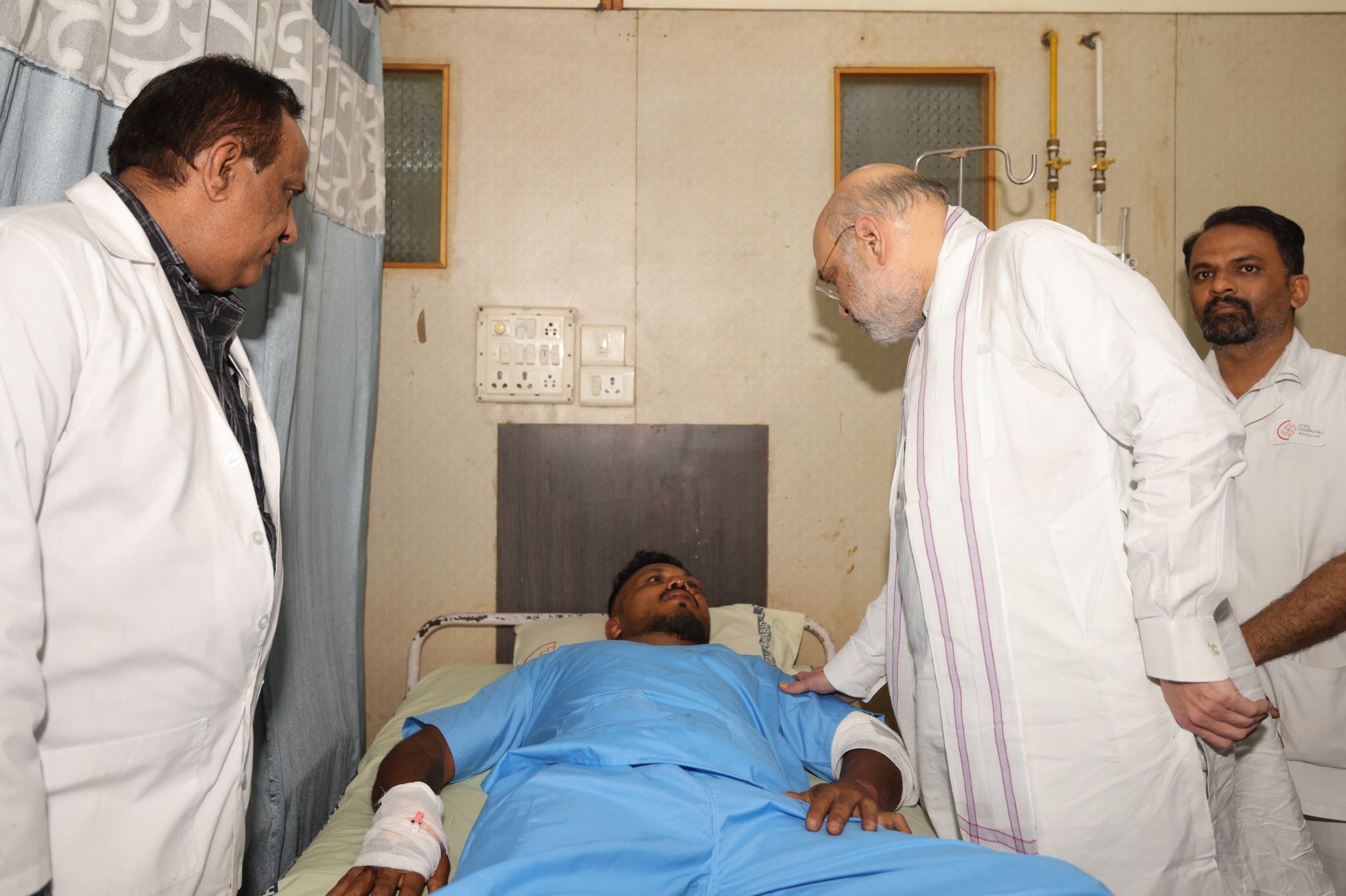 Indian home affairs minister Amit Shah meeting Vishwash Kumar Ramesh in hospital in Ahmedabad (Ministry of Home Affairs India/PA)