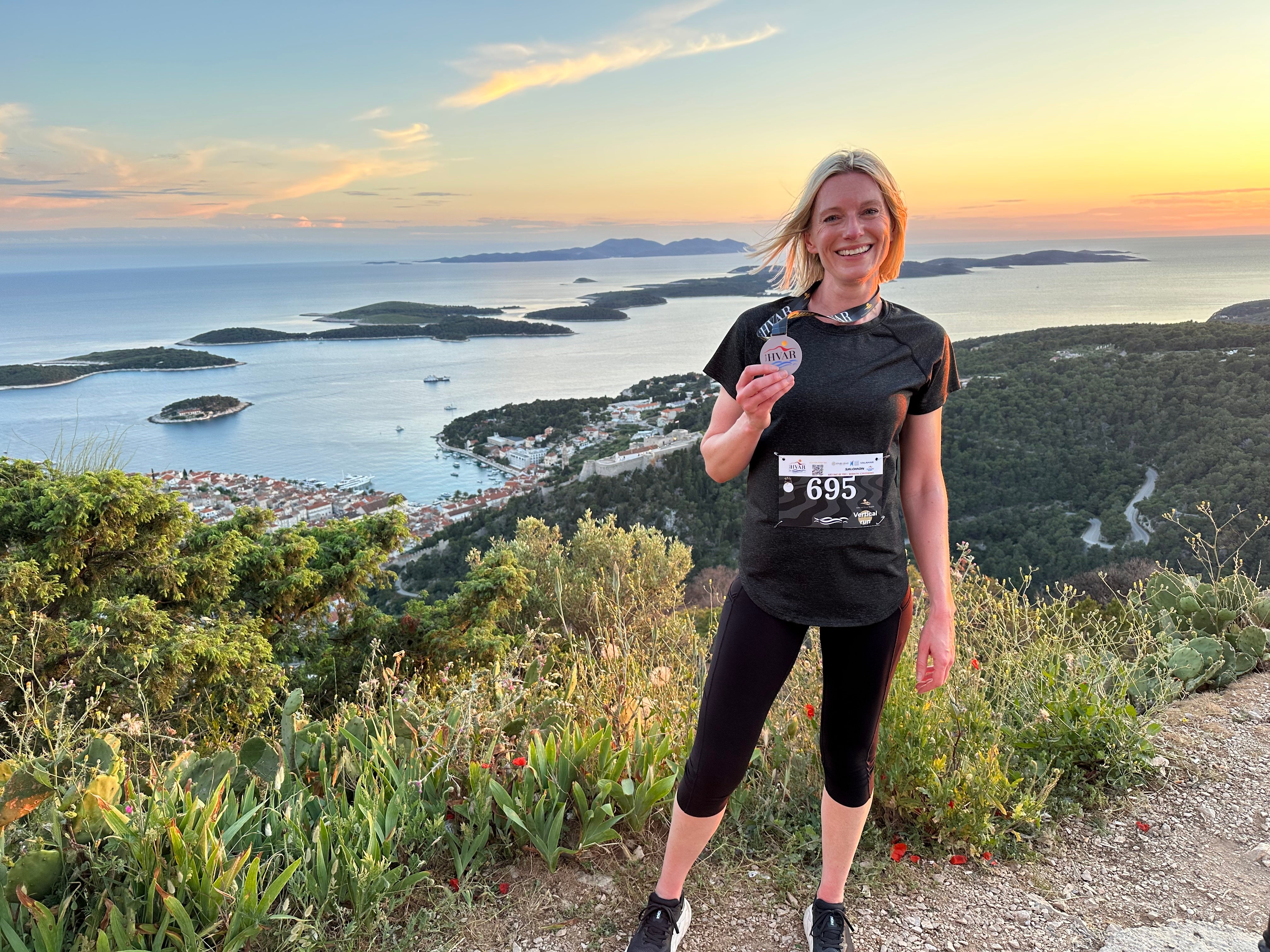 Writer Joanna Booth celebrates with her race medal overlooking Hvar
