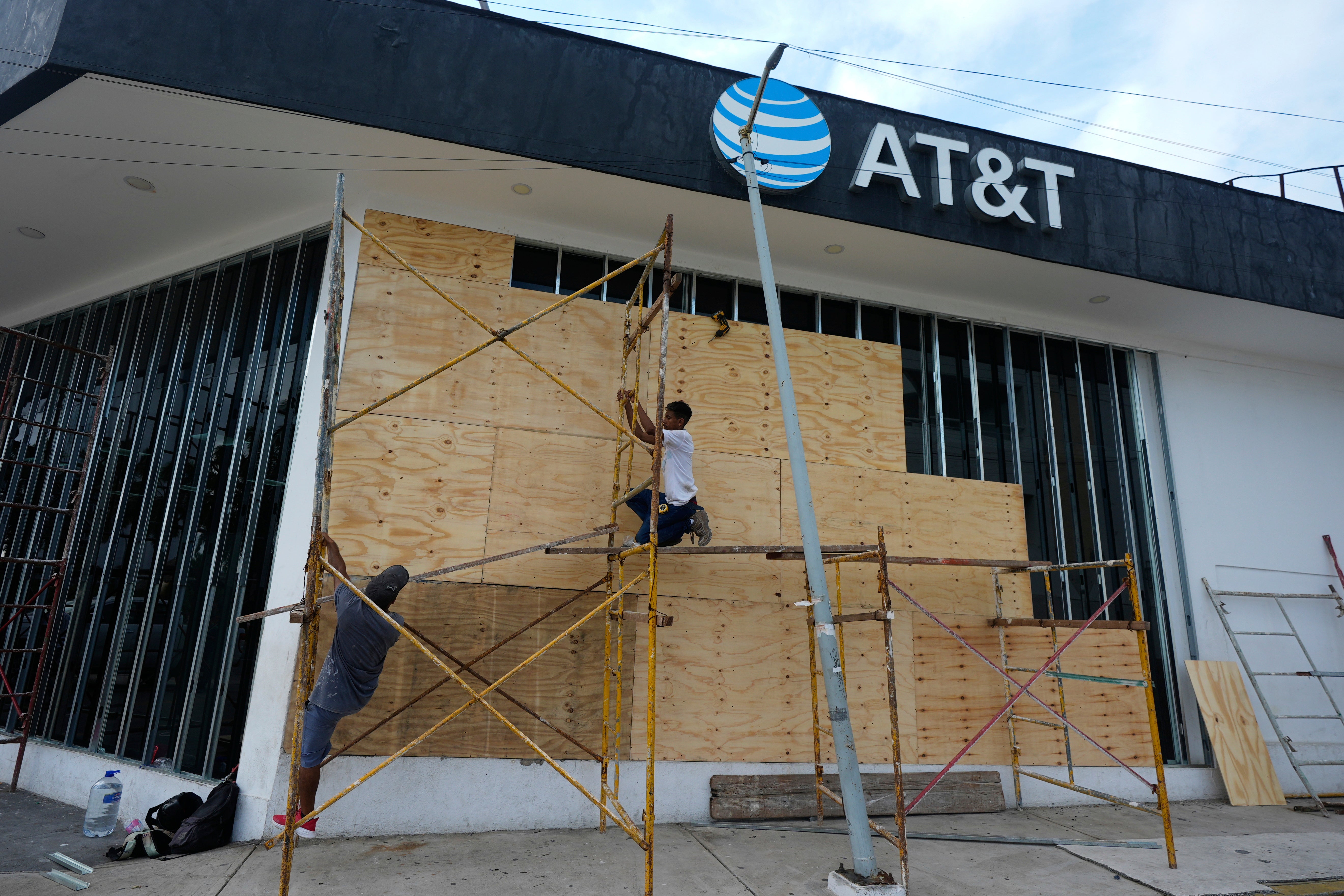Workers board up a storefront as they prepare for the arrival of Hurricane Erick, in Acapulco, Mexico
