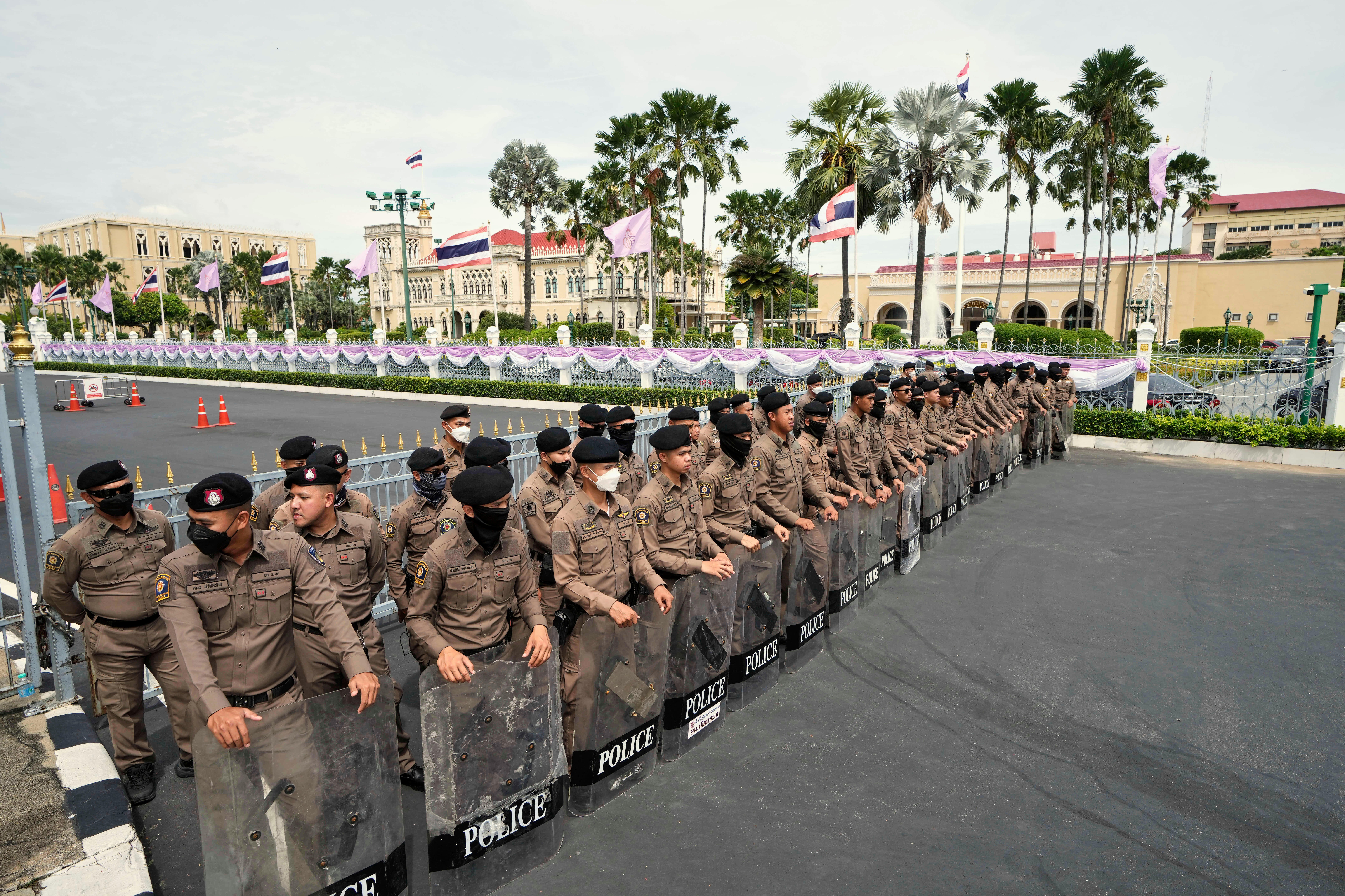 Thai policemen hold shields as anti-government protesters gather in front of Government house demanding Thailand's Prime Minister Paetongtarn Shinawatra resign in Bangkok