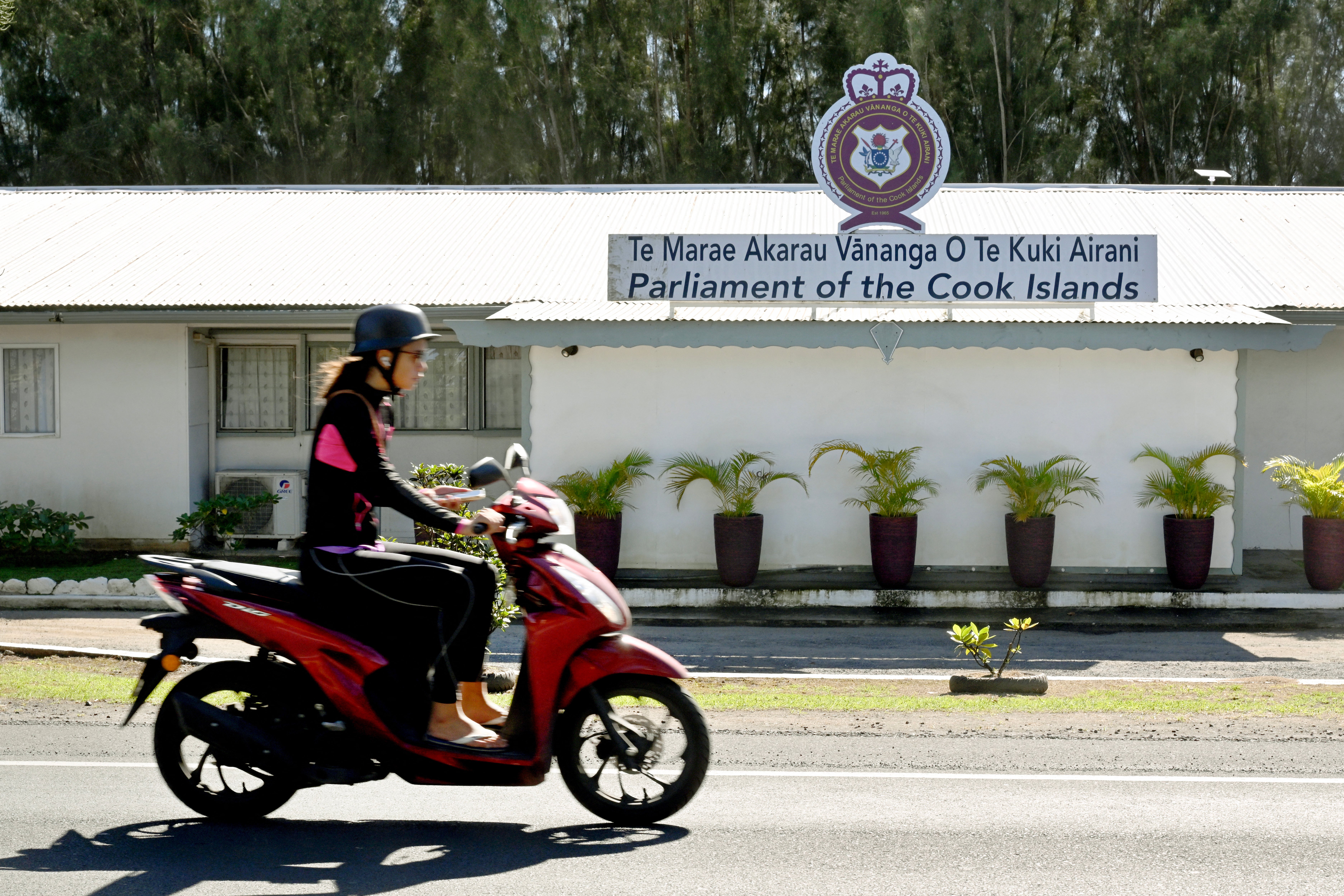 A person riding past the parliament of the Cook Islands on the main island of Rarotonga