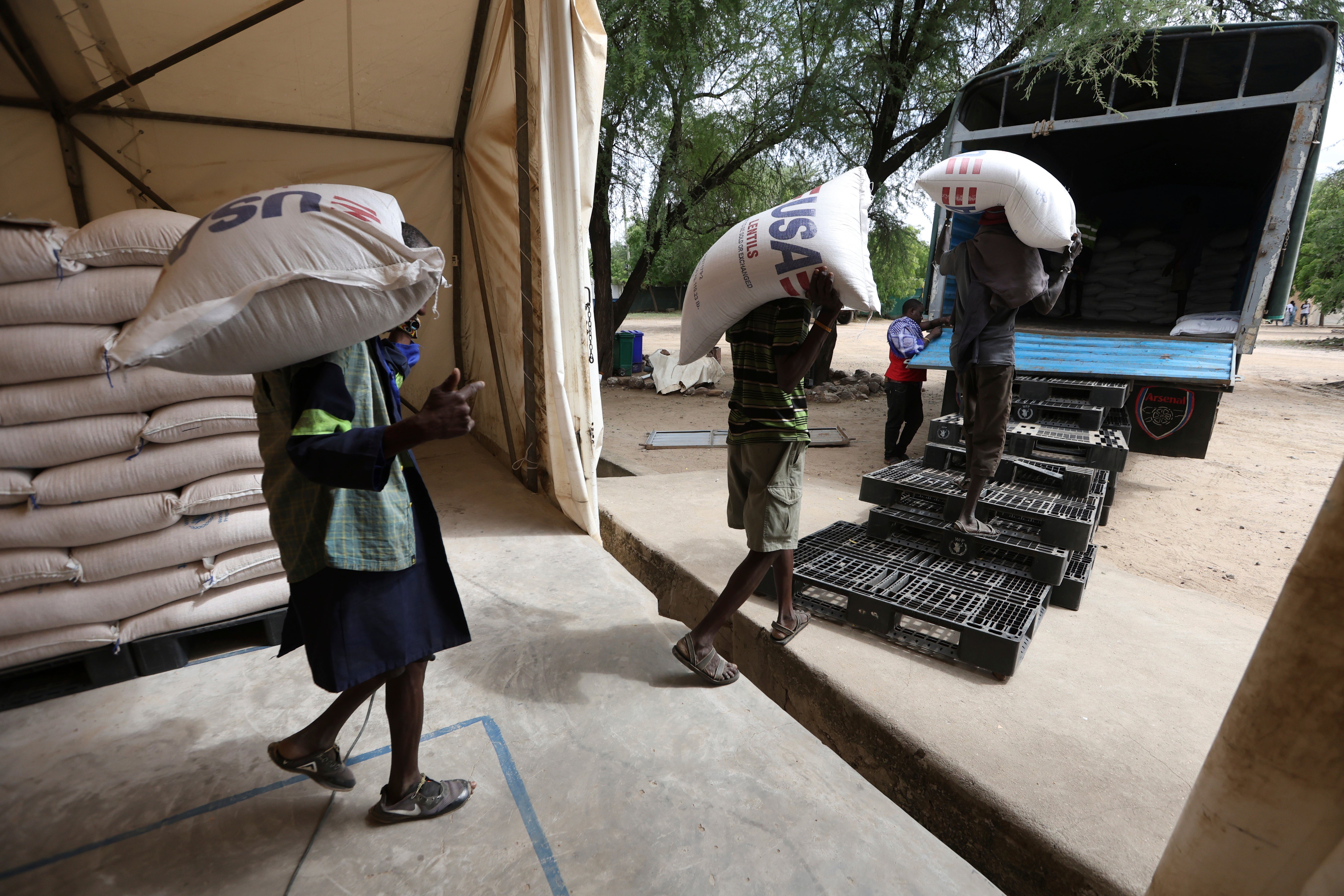 Workers load USAID humanitarian aid into a truck at a World Food Programme warehouse in Kakuma Refugee Camp, Turkana, Kenya