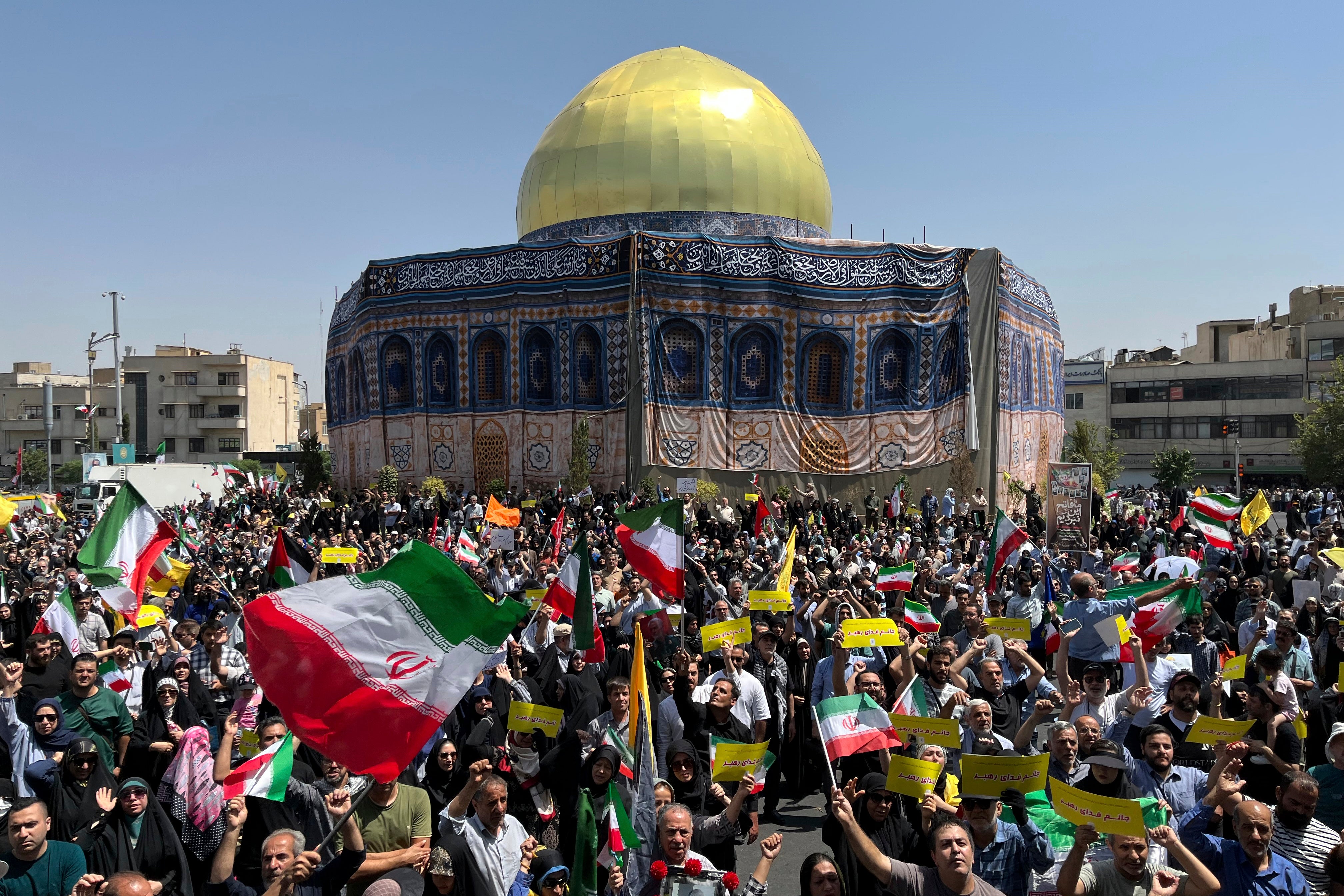 Iranian worshippers wave Iranian flags during a protest against Israeli attacks on multiple cities across Iran, after the Friday prayers at Revolution Square (Enghelab Square) in Tehran, Iran, Friday, June 20, 2025. (AP Photo/Vahid Salemi)