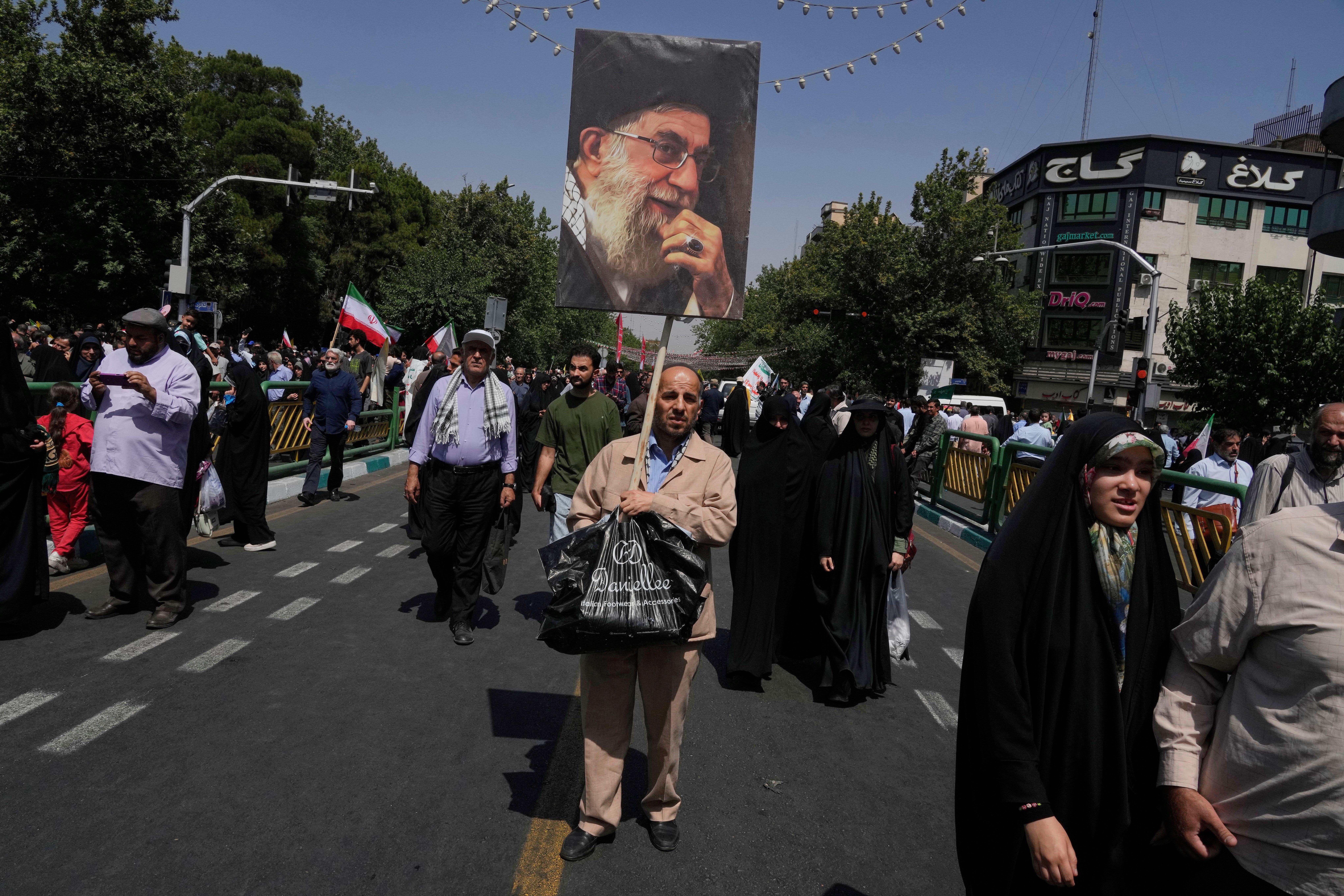 A protester carries a poster of the Iranian Supreme Leader Ayatollah Ali Khamenei during a protest to condemn Israeli attacks on multiple cities across Iran, after the Friday prayers ceremony in Tehran, Iran, Friday, June 20, 2025. (AP Photo/Vahid Salemi)