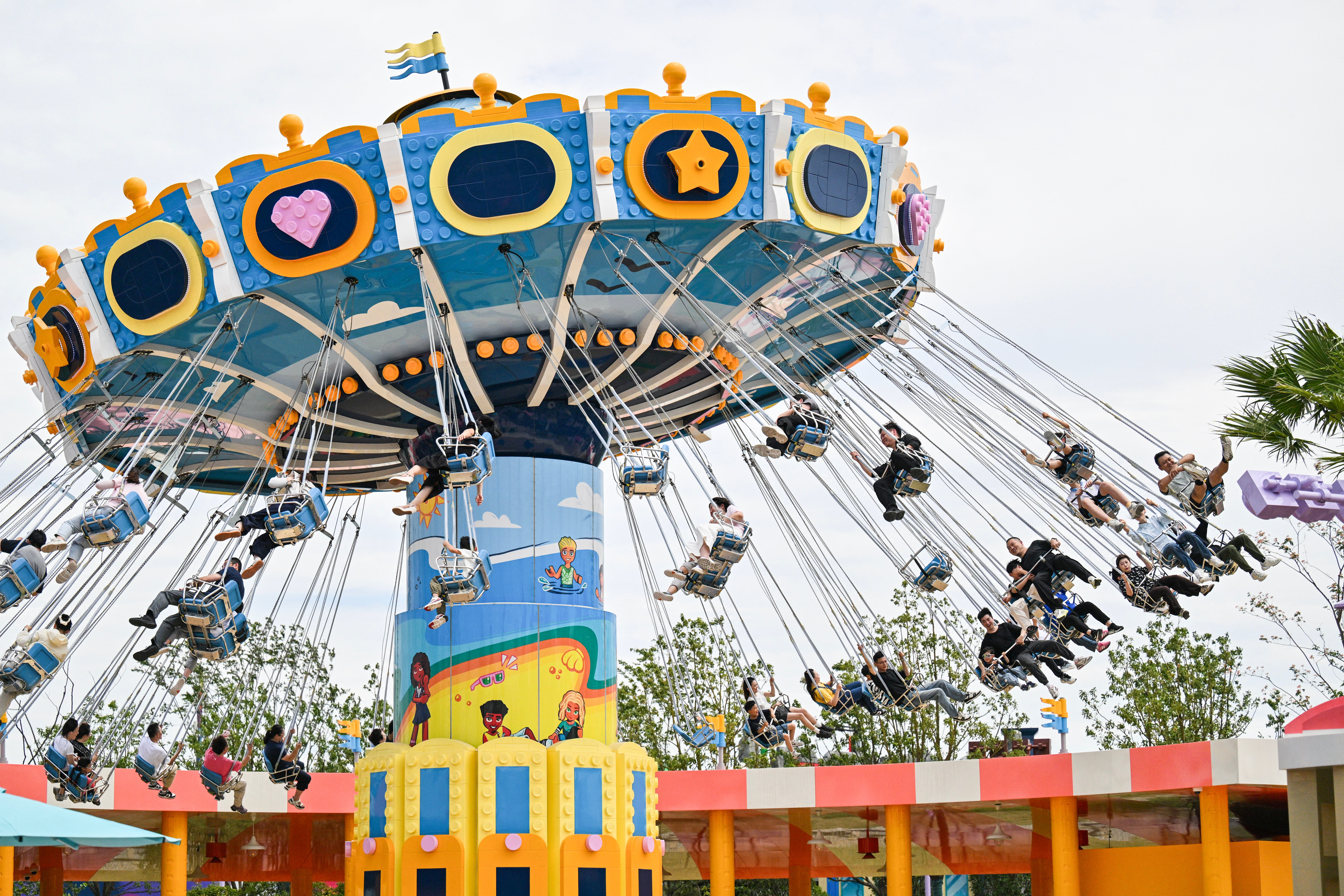 People ride flying chairs at the new Legoland Shanghai Resort