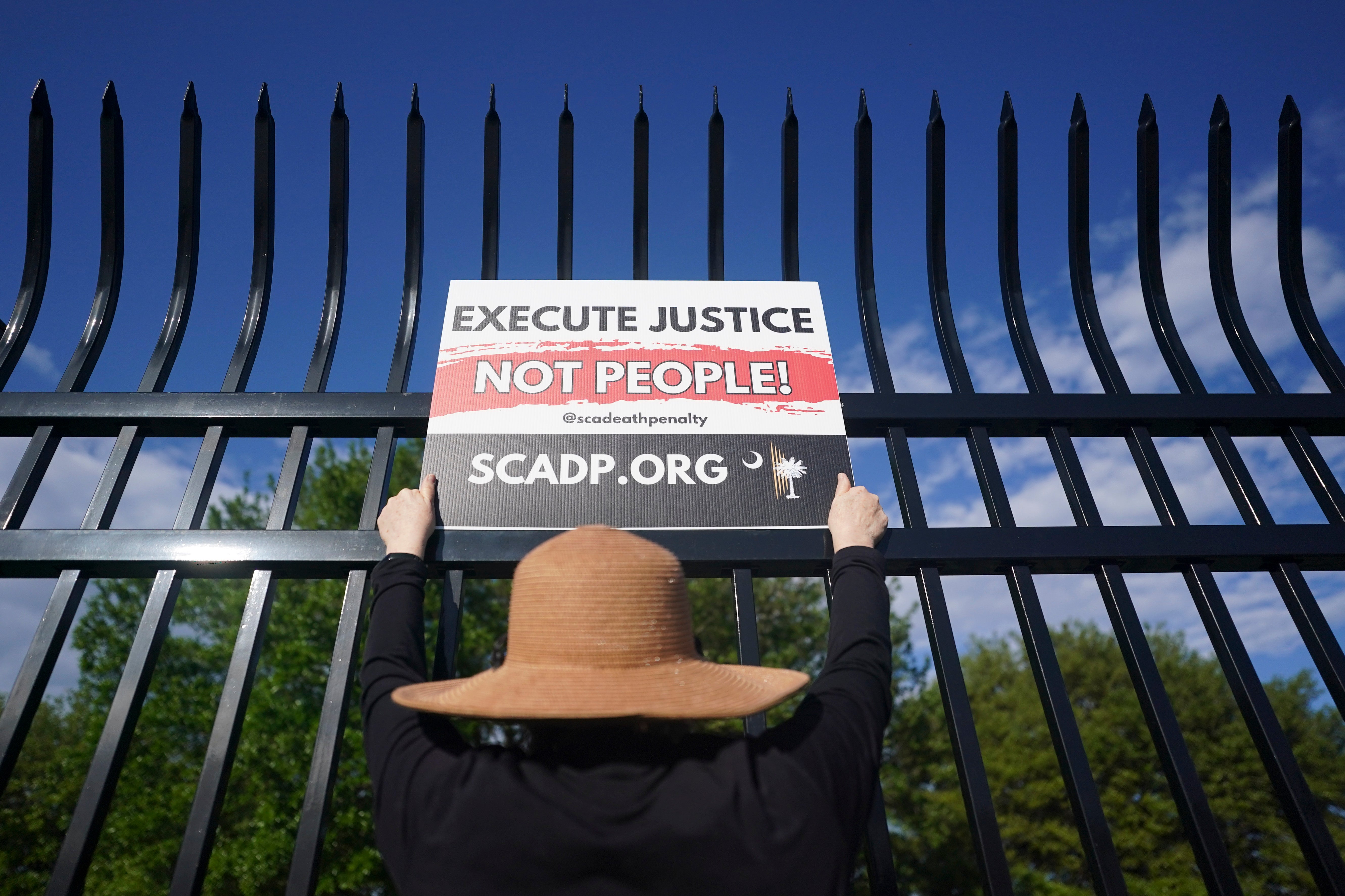 A demonstrator holds a sign against capital punishment outside the department of corrections before the scheduled firing squad execution of South Carolina inmate Mikal Mahdi on April 11. His execution marked the second time in five weeks that the state carried out the death penalty by firing squad.