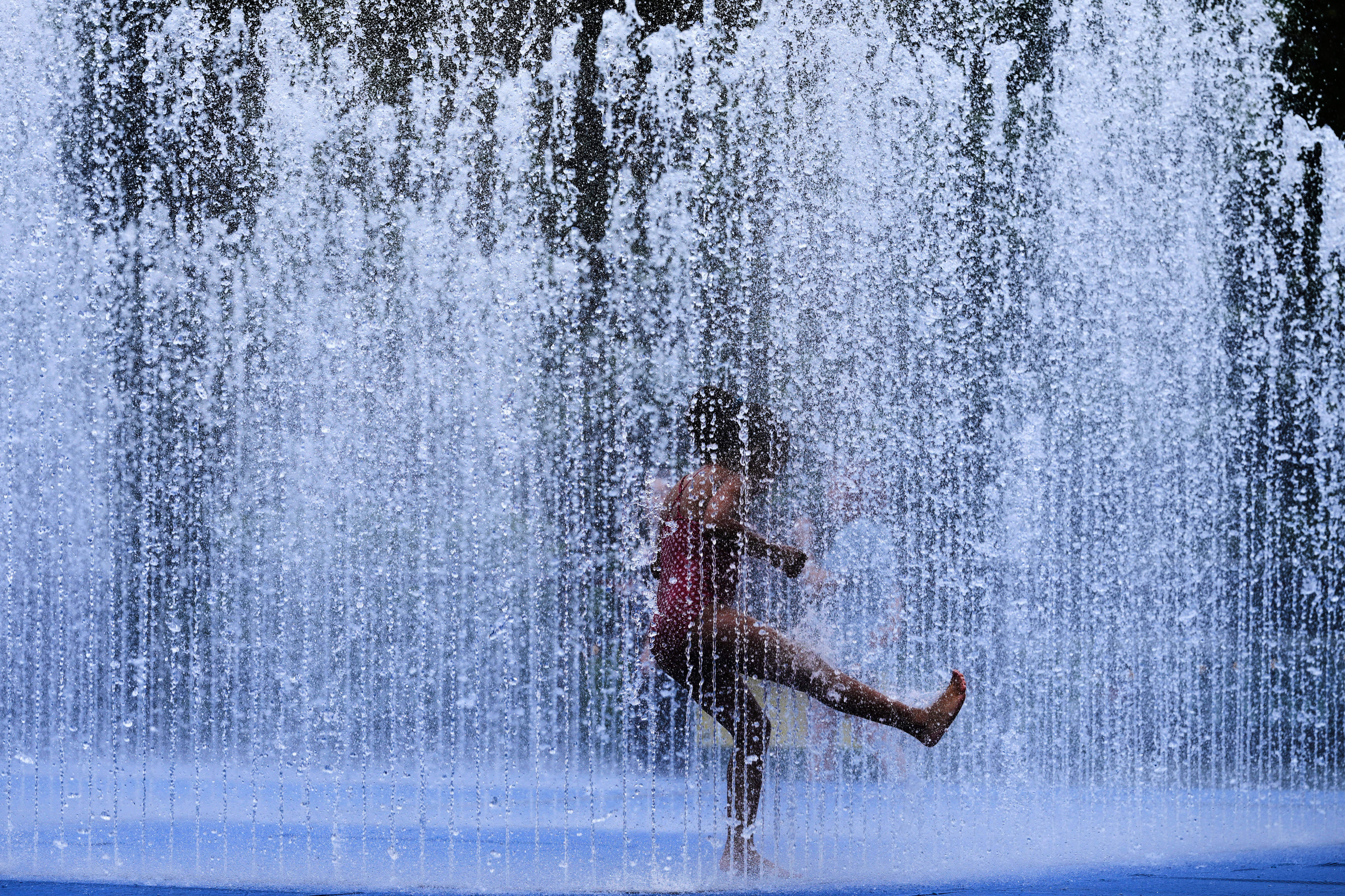 A child plays in a fountain in London, as a heatwave passes through the capital