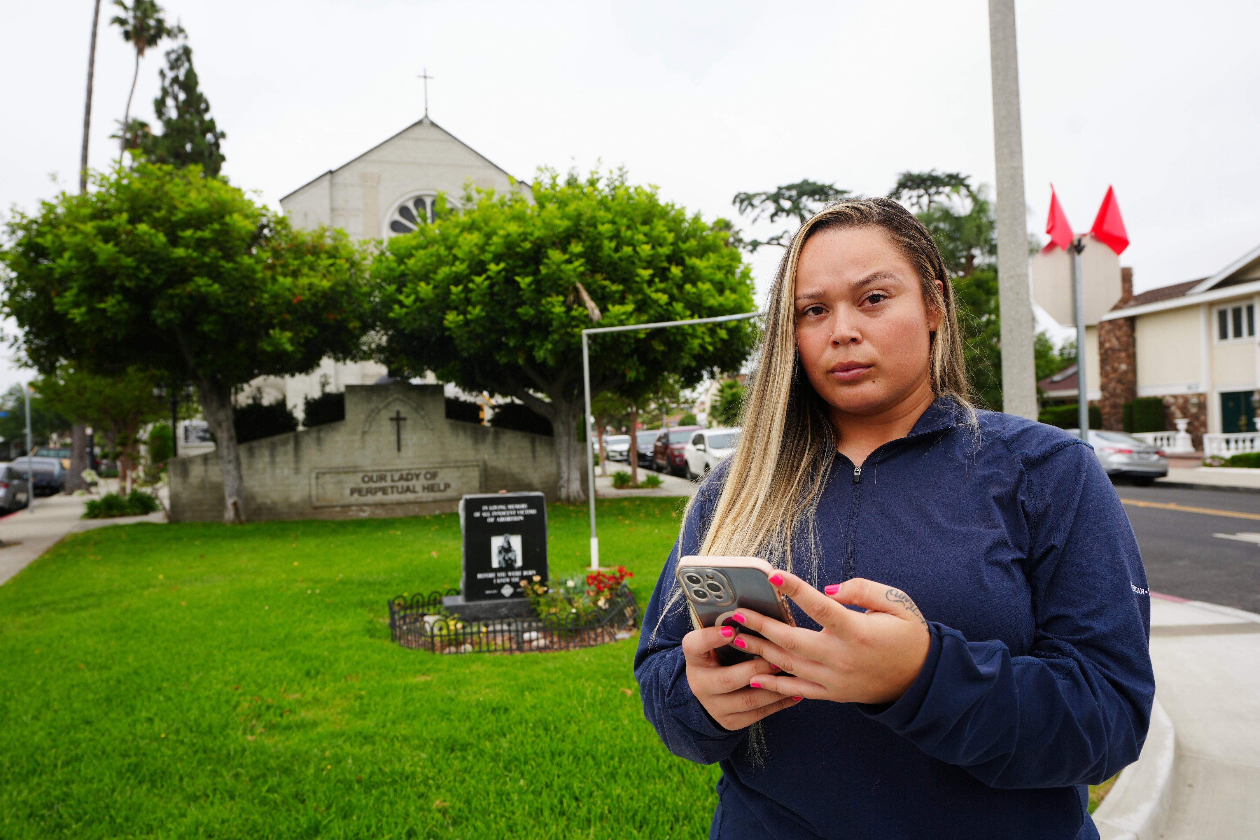 Melyssa Rivas poses for a photo at a location where she witnessed masked federal agents detaining a person earlier this month outside Our Lady of Perpetual Help Catholic Church in Downey, Calif., on Friday, June 20, 2025. (AP Photo/Damian Dovarganes)