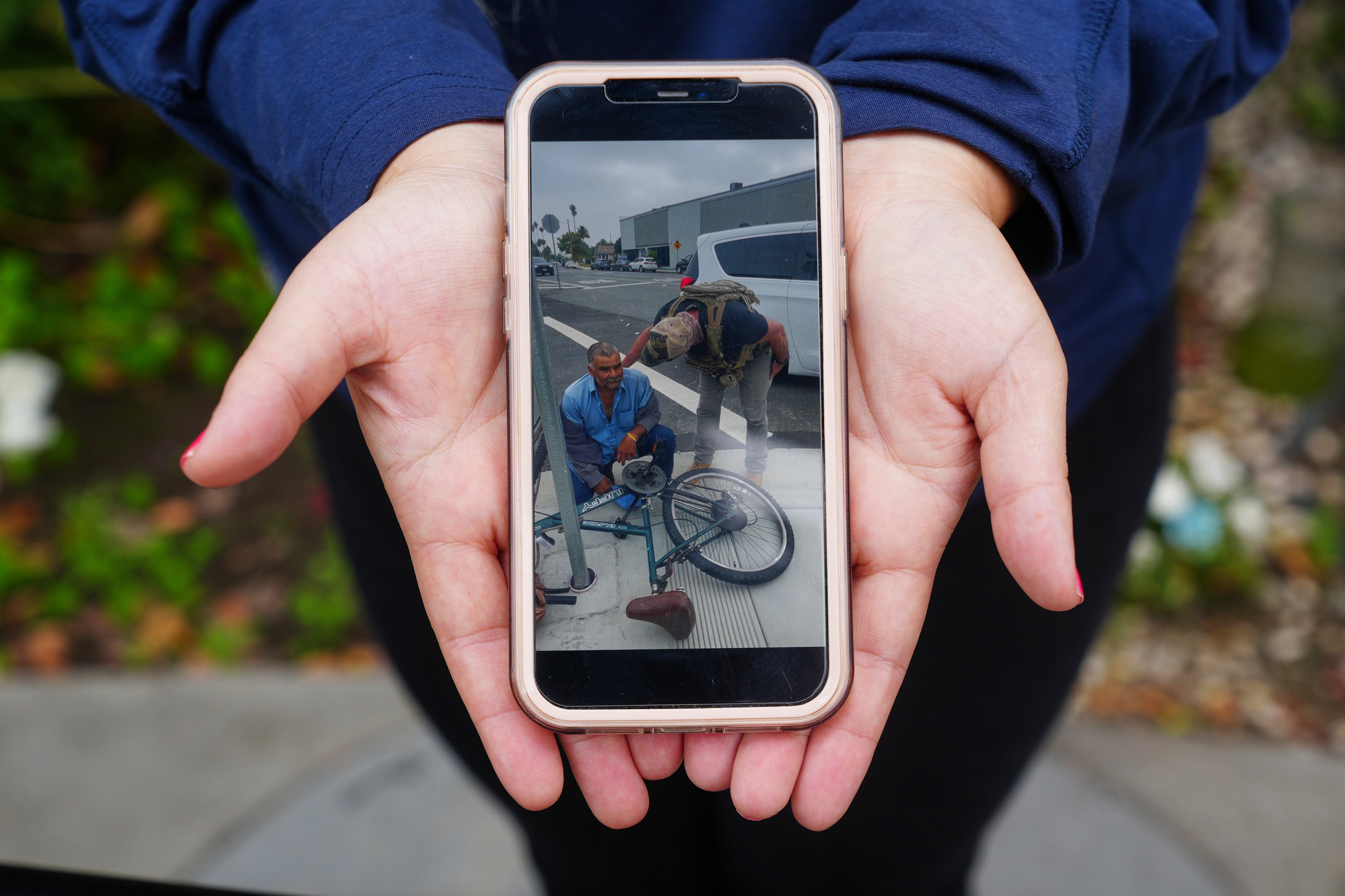 Melyssa Rivas shows her video of masked federal agents detaining a person earlier this month outside Our Lady of Perpetual Help Catholic Church in Downey, Calif., on Friday, June 20, 2025. (AP Photo/Damian Dovarganes)