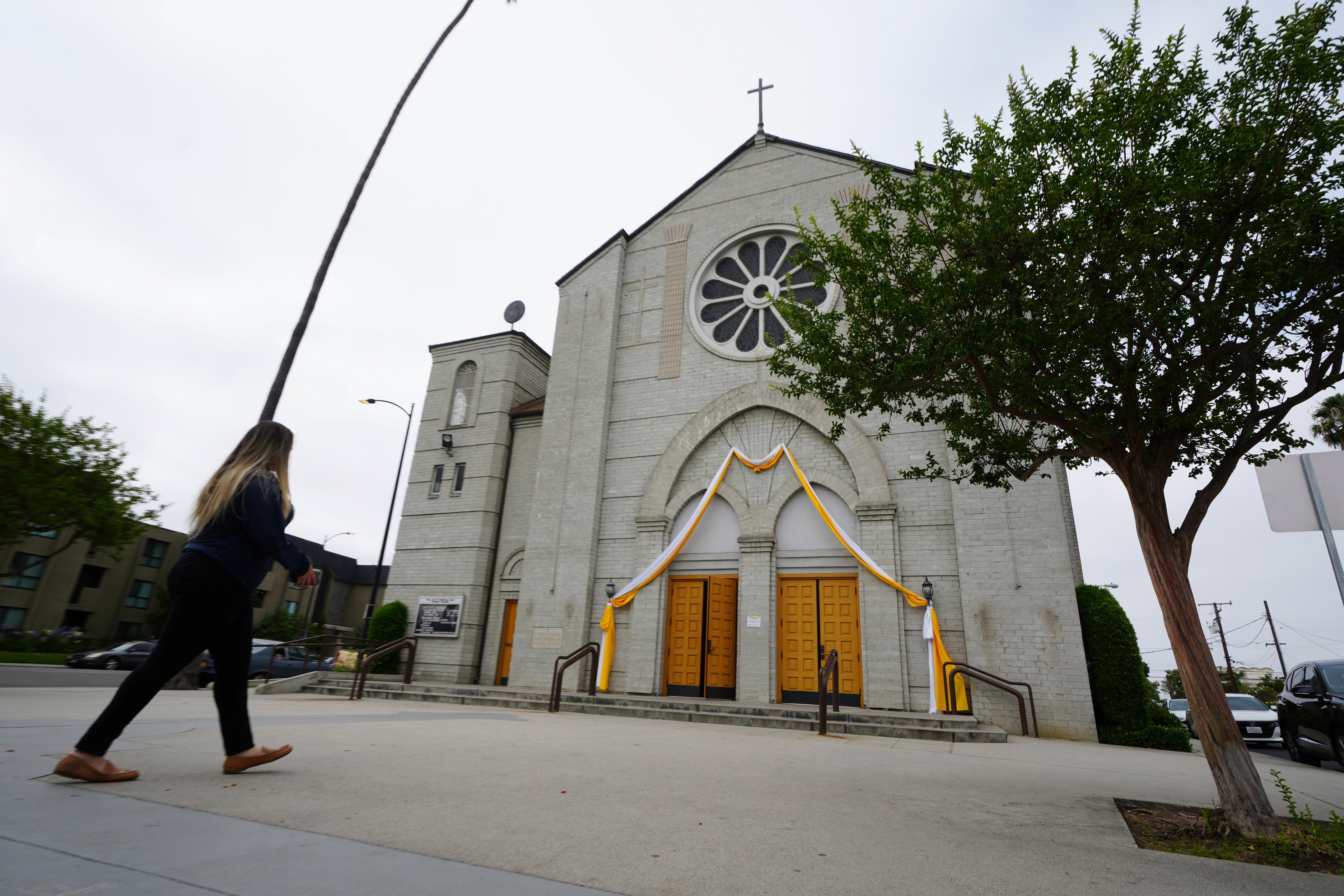 Melyssa Rivas walks outside a location where she witnessed masked federal agents detaining a person earlier this month outside Our Lady of Perpetual Help Catholic Church in Downey, Calif., on Friday, June 20, 2025. (AP Photo/Damian Dovarganes)
